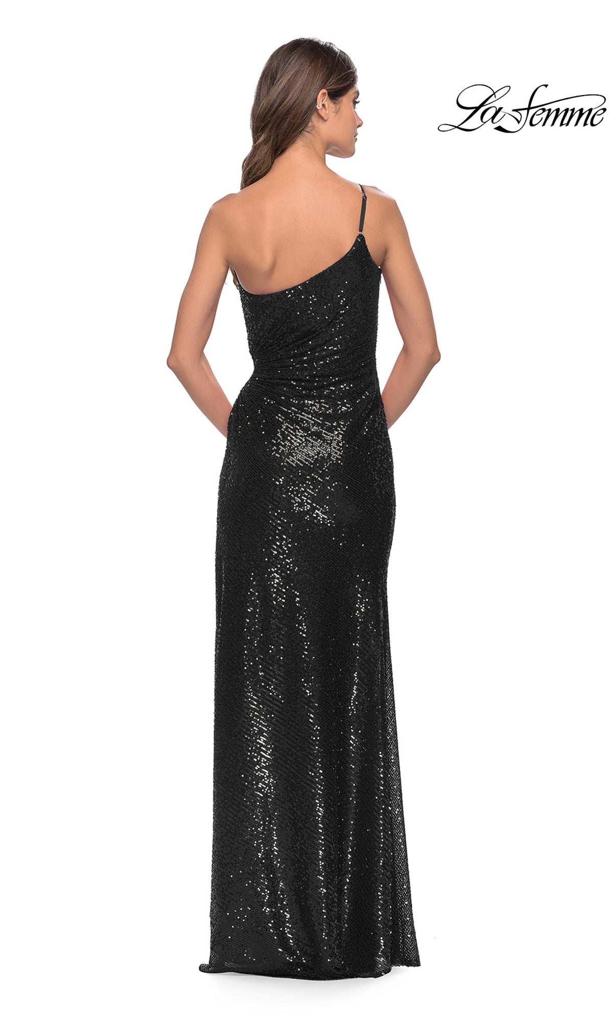 A woman in a black La Femme One-Shoulder Long Sequin Prom Dress 31089 stands facing away, showcasing the dress’s stunning back. The La Femme logo is visible in the upper right corner.