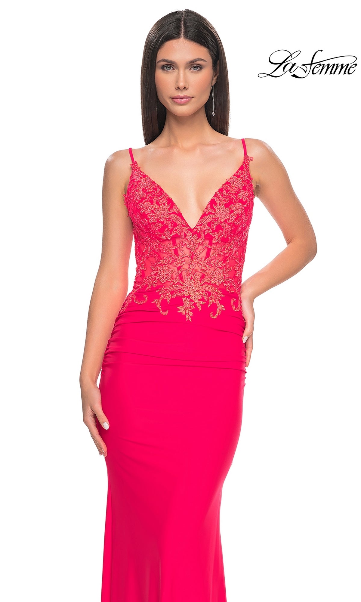 Woman wearing the La Femme Sheer-Waist Long V-Neck Prom Dress 31128 in bright pink, featuring an intricately embroidered lace bodice, poses against a plain white background.