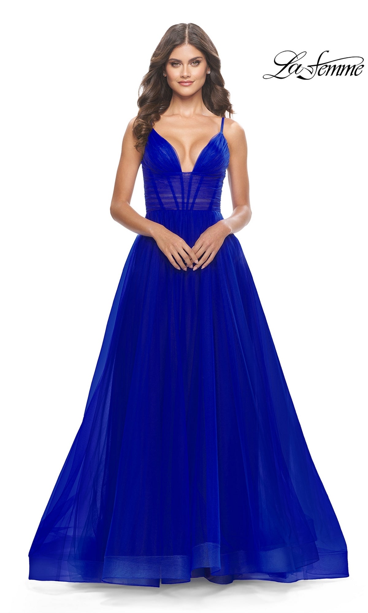 A woman models the Sheer-Waist La Femme Long Prom Ball Gown 31147 in deep blue, featuring a fitted bodice and tulle skirt, against a white background. The