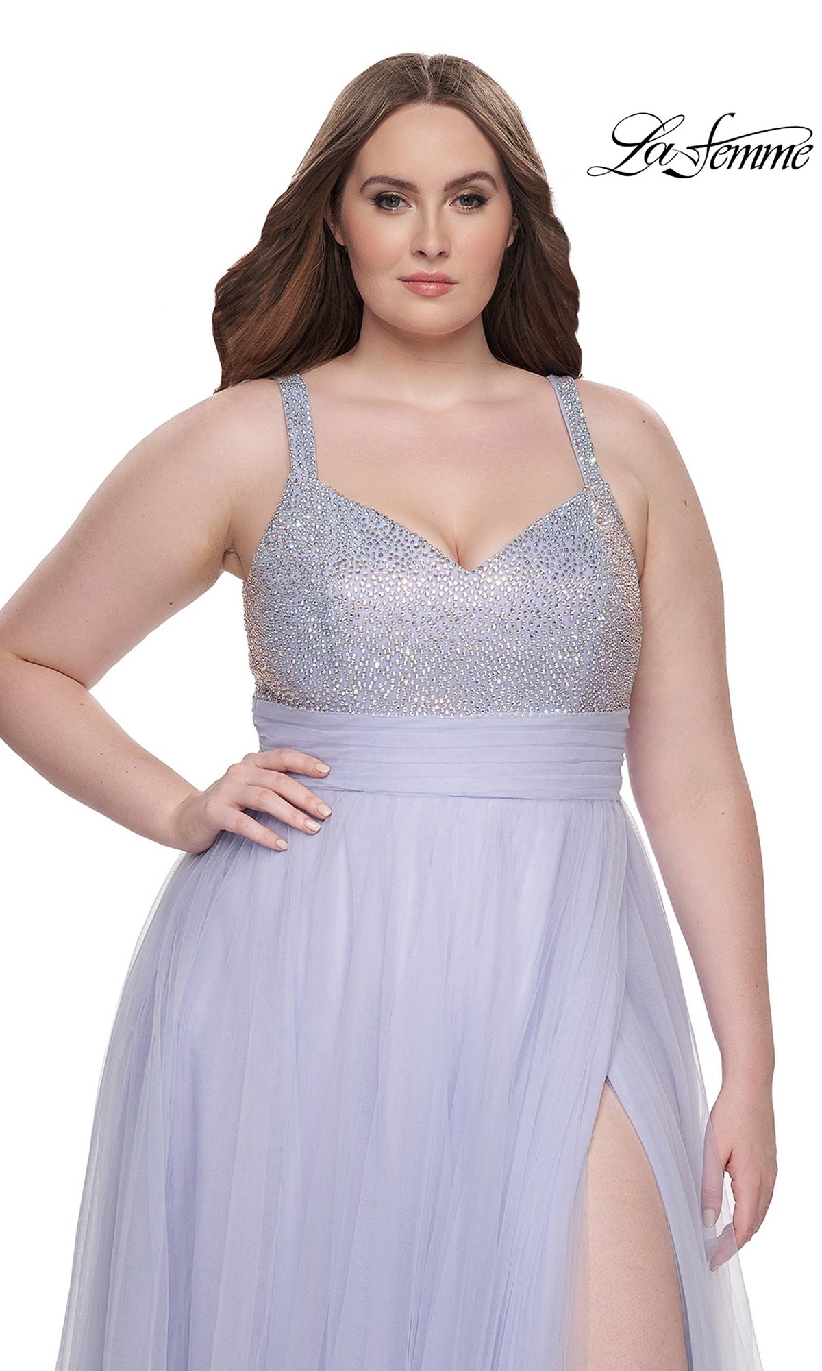A woman wears the La Femme Long Prom Dress 31251, a light purple plus-size gown featuring a beaded bodice and high slit. The