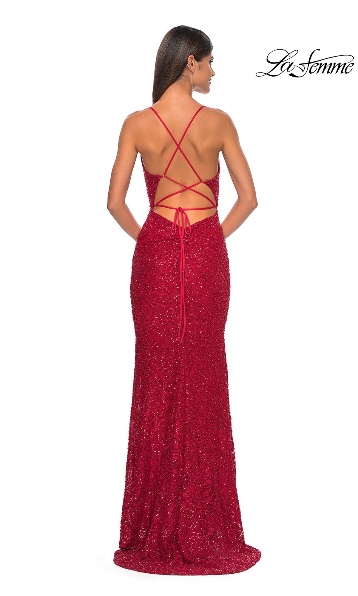 A woman wears the La Femme Long Beaded Lace Prom Dress 31359, a floor-length, red sequined gown with a fitted silhouette and crisscross lace-up open back. The La Femme logo is shown in the top right corner.