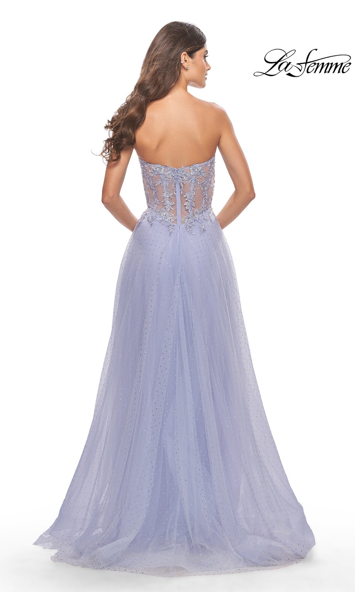A woman is shown from behind in the La Femme Strapless Sheer-Waist Prom Dress 31367, featuring delicate lace embroidery, a sheer embellished back, and a flowing A-line tulle skirt.