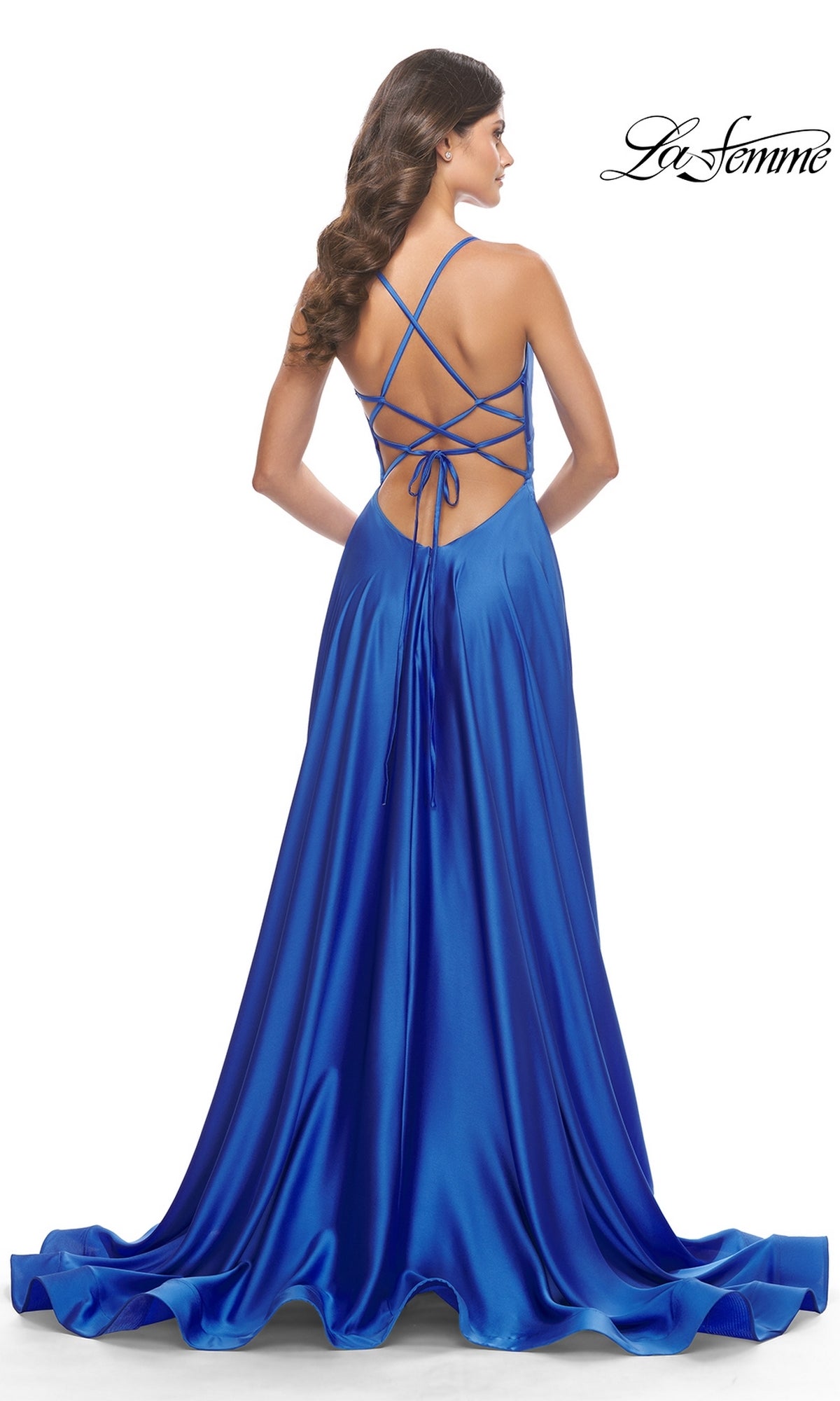 A woman stands with her back to the camera, wearing the La Femme 31533 Deep V-Neck Long A-Line Prom Dress in royal blue, featuring a crisscross open back and lace-up detailing.