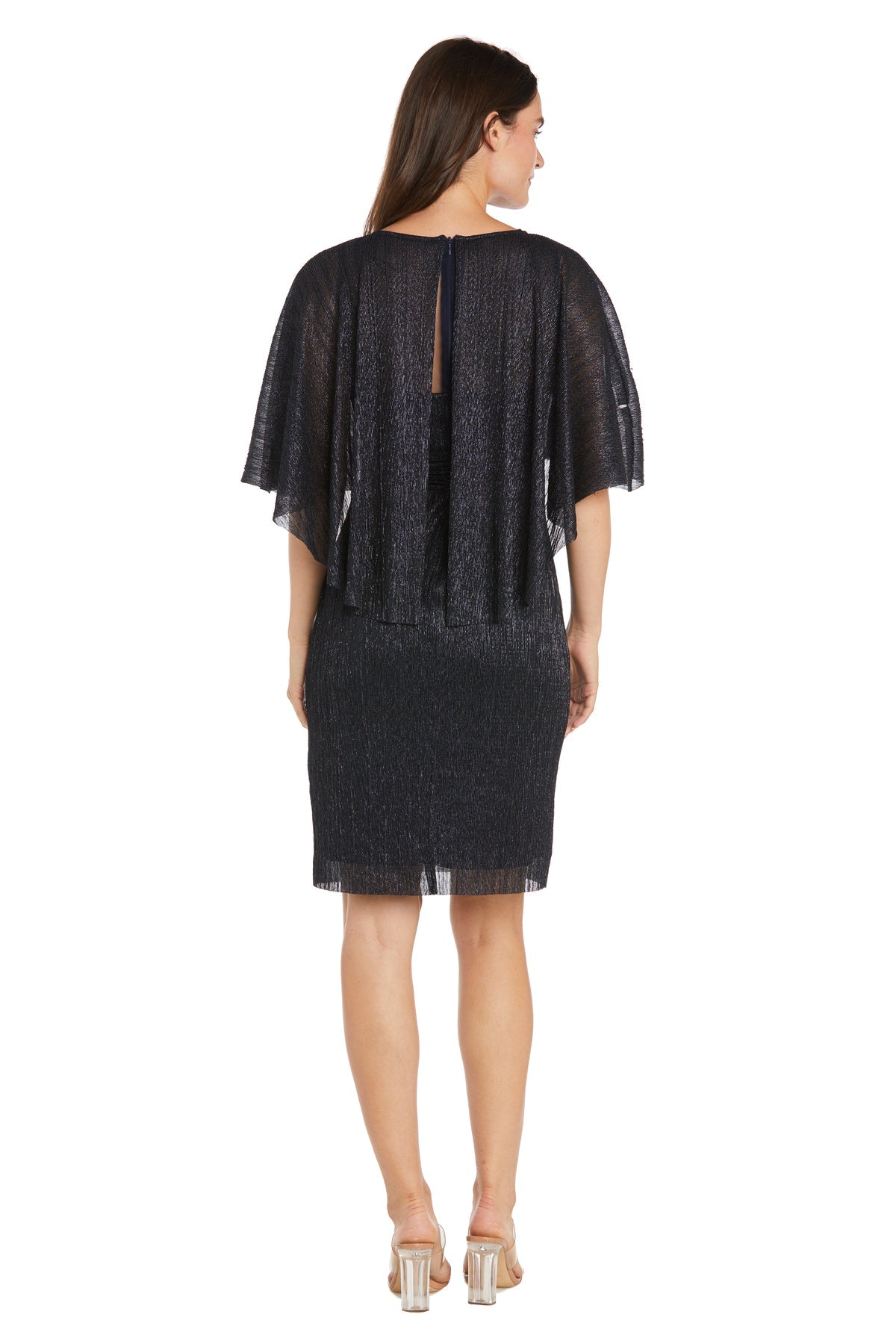 A woman faces away, wearing the R&M Richards 3195P Caped Knee-Length Party Dress with a sheer chiffon cape overlay and clear heels, posing against a plain white background.