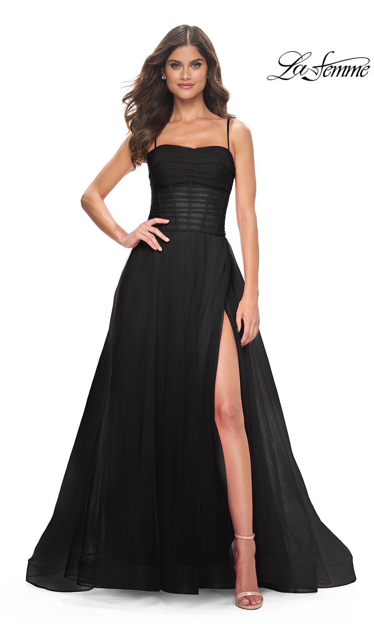 A woman models the La Femme Sheer-Waist Long Prom Ball Gown 32017, featuring spaghetti straps, a sheer corset bodice, and a high slit. She stands against a white background with the