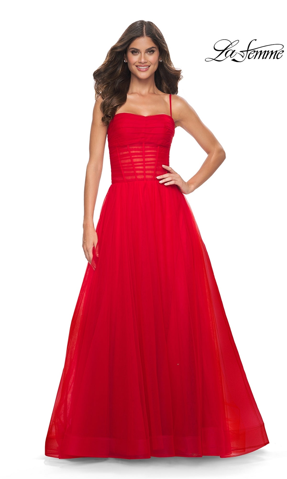 A woman wears the La Femme Sheer-Waist Long Prom Ball Gown 32017, a sleeveless, floor-length red dress with a fitted bodice and tulle skirt, standing against a white background. The La Femme logo appears in the top right corner.