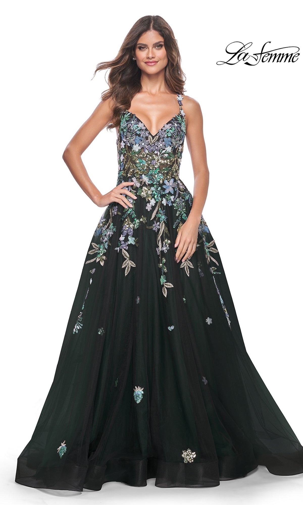 A woman wears the La Femme Sequin Flower-Print Long Prom Dress 32023, a black A-line gown with thin straps, a fitted bodice, and sequin floral embroidery, standing against a white background.