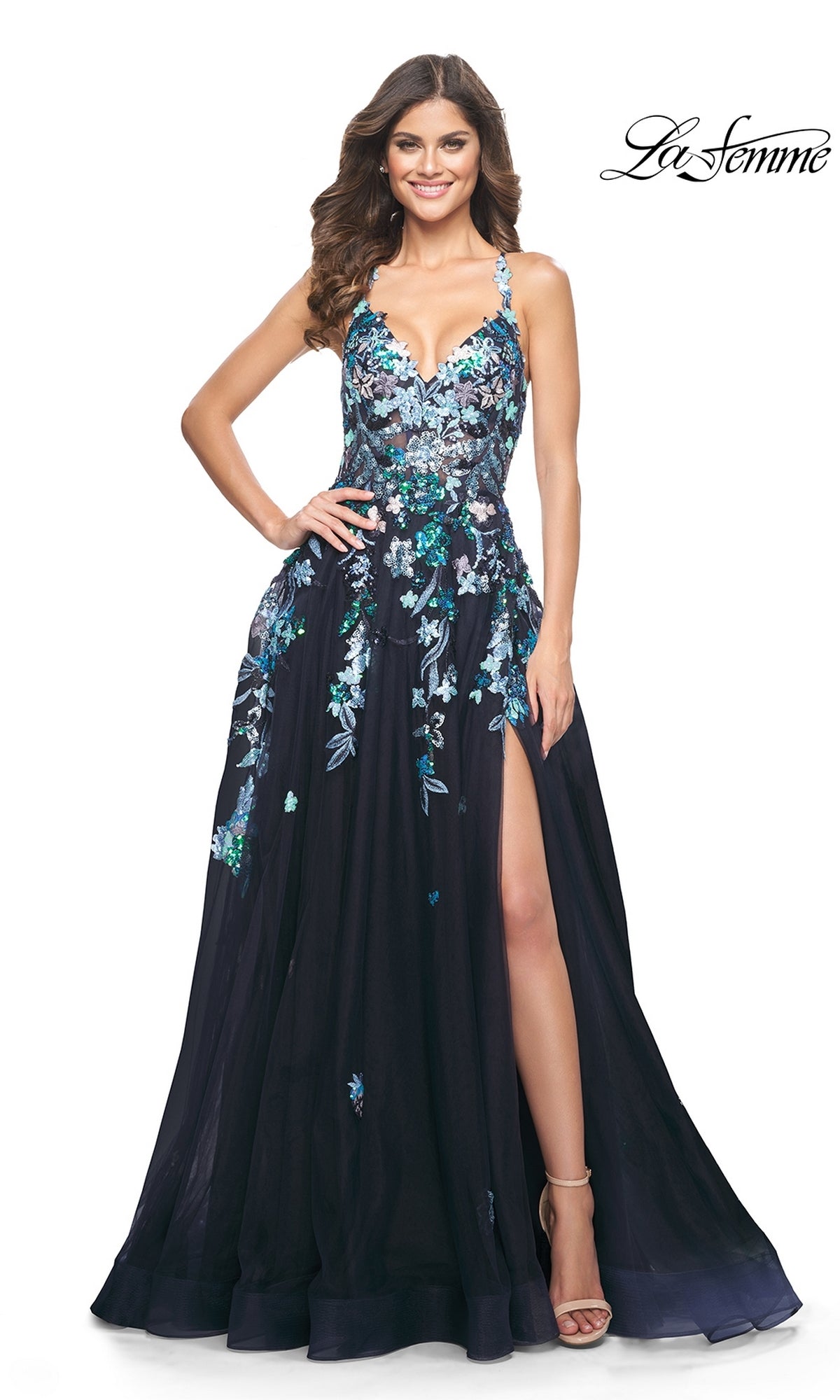 A woman wears the La Femme Sequin Flower-Print Long Prom Dress 32023, featuring navy blue sequined floral embroidery, high slit, spaghetti straps, and open-toe heels. The
