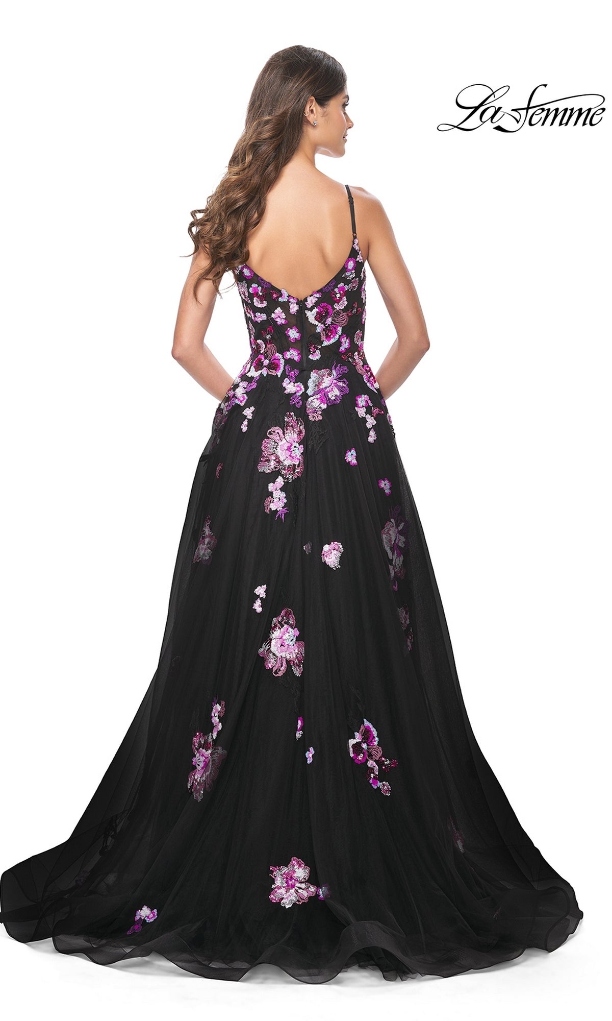 A woman is shown from the back in the La Femme Purple-Floral Long Black Prom Dress 32030, featuring pink and purple sequin flowers, thin straps, a fitted bodice, and a floor-length A-line silhouette.