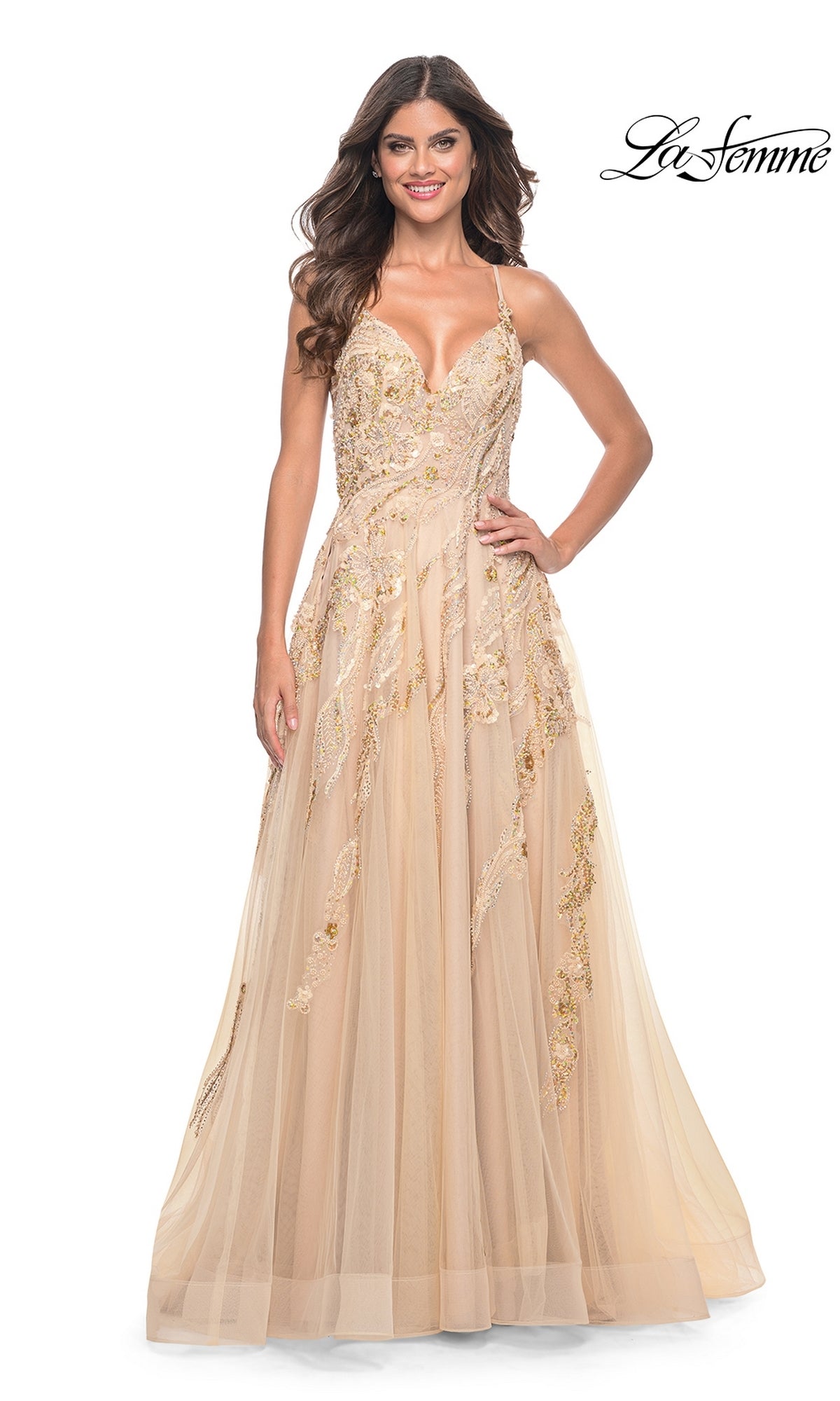 A woman in the La Femme Sequin-Lace Long A-Line Prom Dress 32032, a beige floor-length sleeveless gown with gold embroidery, stands smiling against a white background. The La Femme logo appears in the top right corner.