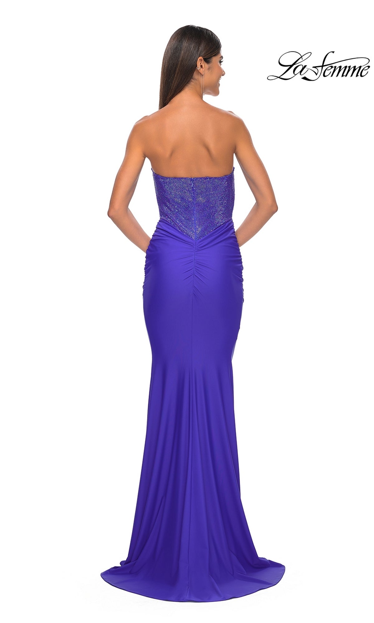 Model shown from the back wearing La Femme 32069: a strapless sweetheart prom dress with a fitted bodice, ruched detailing, hot-stone beading, and floor-length purple skirt.