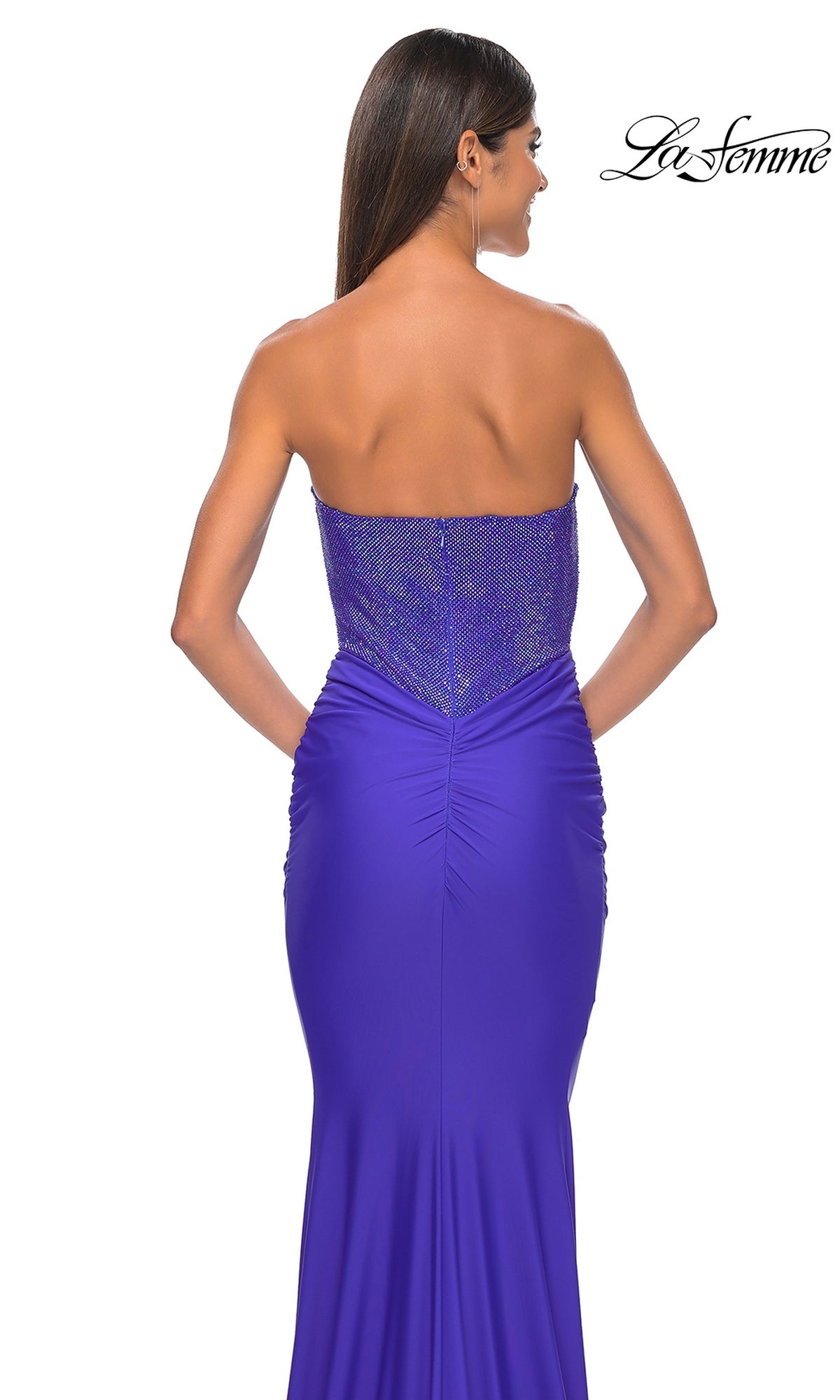 A woman with long brown hair wears the Strapless Sweetheart Prom Dress La Femme 32069 in purple, featuring a textured bodice and shown from the back.
