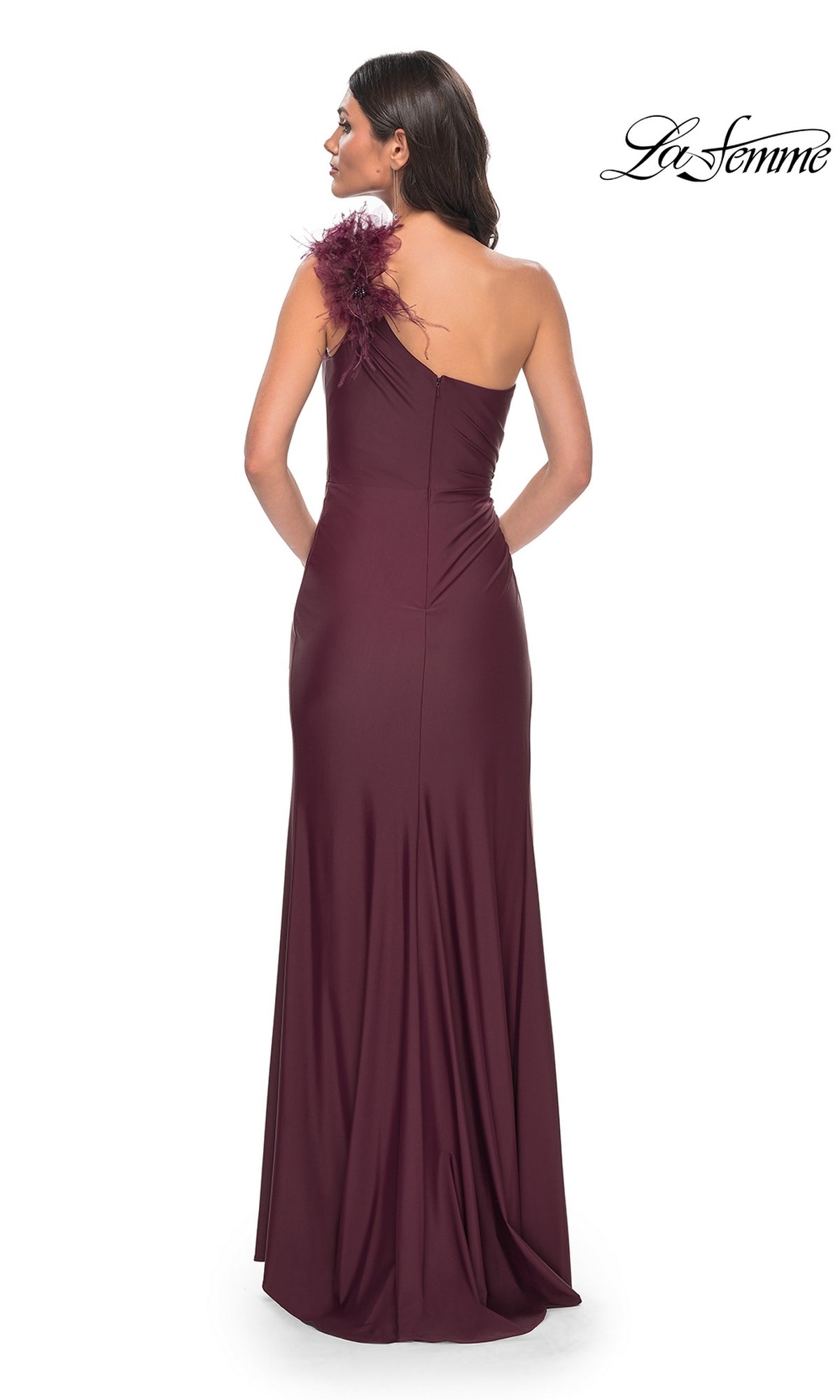Woman shown from the back wearing the La Femme Feathered One-Shoulder Prom Dress 32076, a floor-length gown featuring a feather detail at the shoulder.
