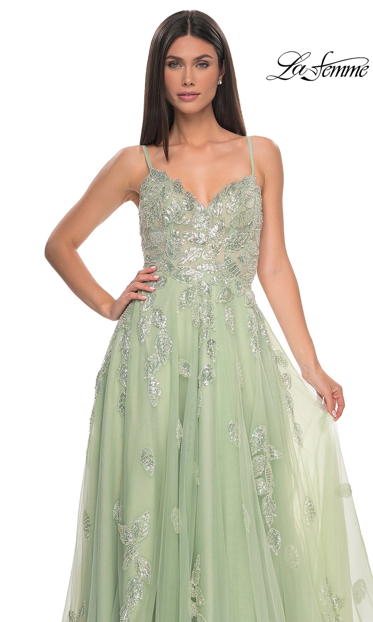 A woman poses against a white background in the La Femme Sequin-Embroidered Long Prom Dress 32090, a light green A-line gown featuring silver floral embellishments and delicate sequin embroidery.