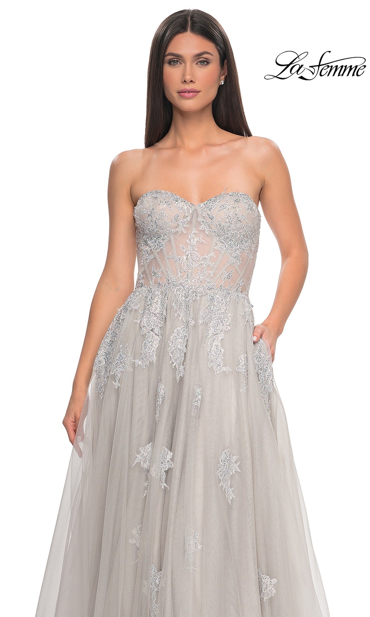 A woman stands against a plain white background wearing the La Femme Strapless Long A-Line Prom Dress 32111, featuring intricate embroidered-lace appliques and a sheer bodice.