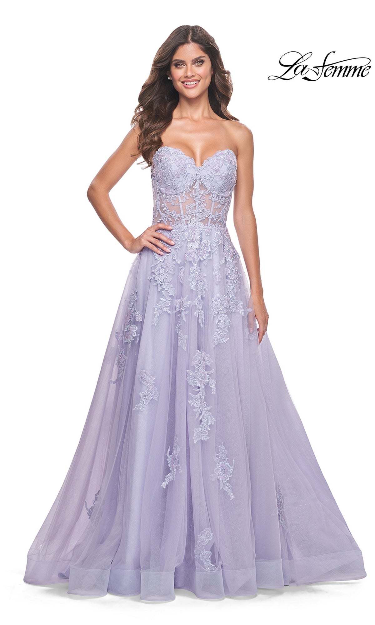 A woman wears the La Femme Strapless Long Lace Prom Dress 32145 in lavender, featuring embroidered floral lace appliqué and a sheer corset bodice. The La Femme logo is in the upper right corner.