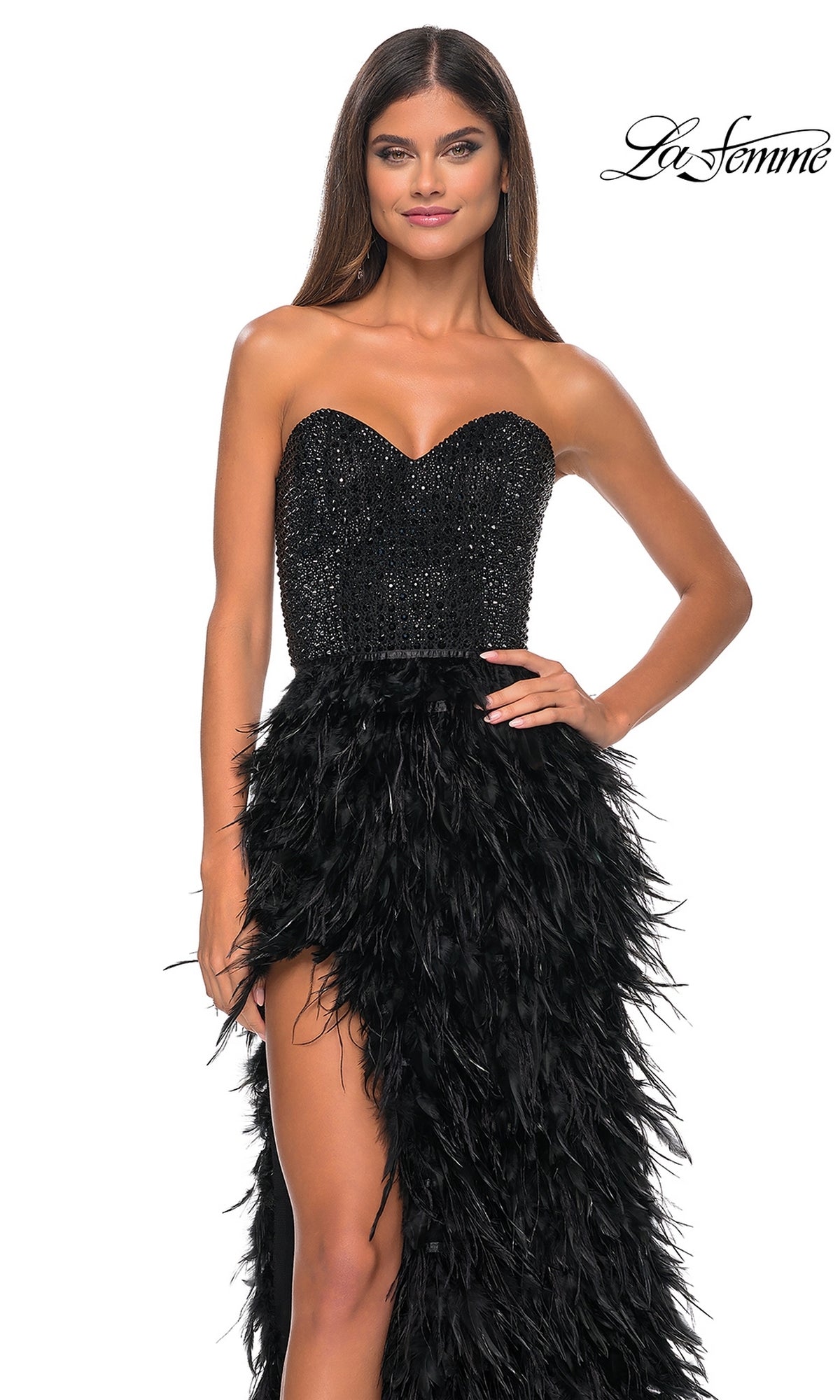 A woman poses with one hand on her hip against a white background, wearing the La Femme Feather Strapless Long Prom Dress 32165 featuring an embellished sweetheart bodice and feathered skirt.