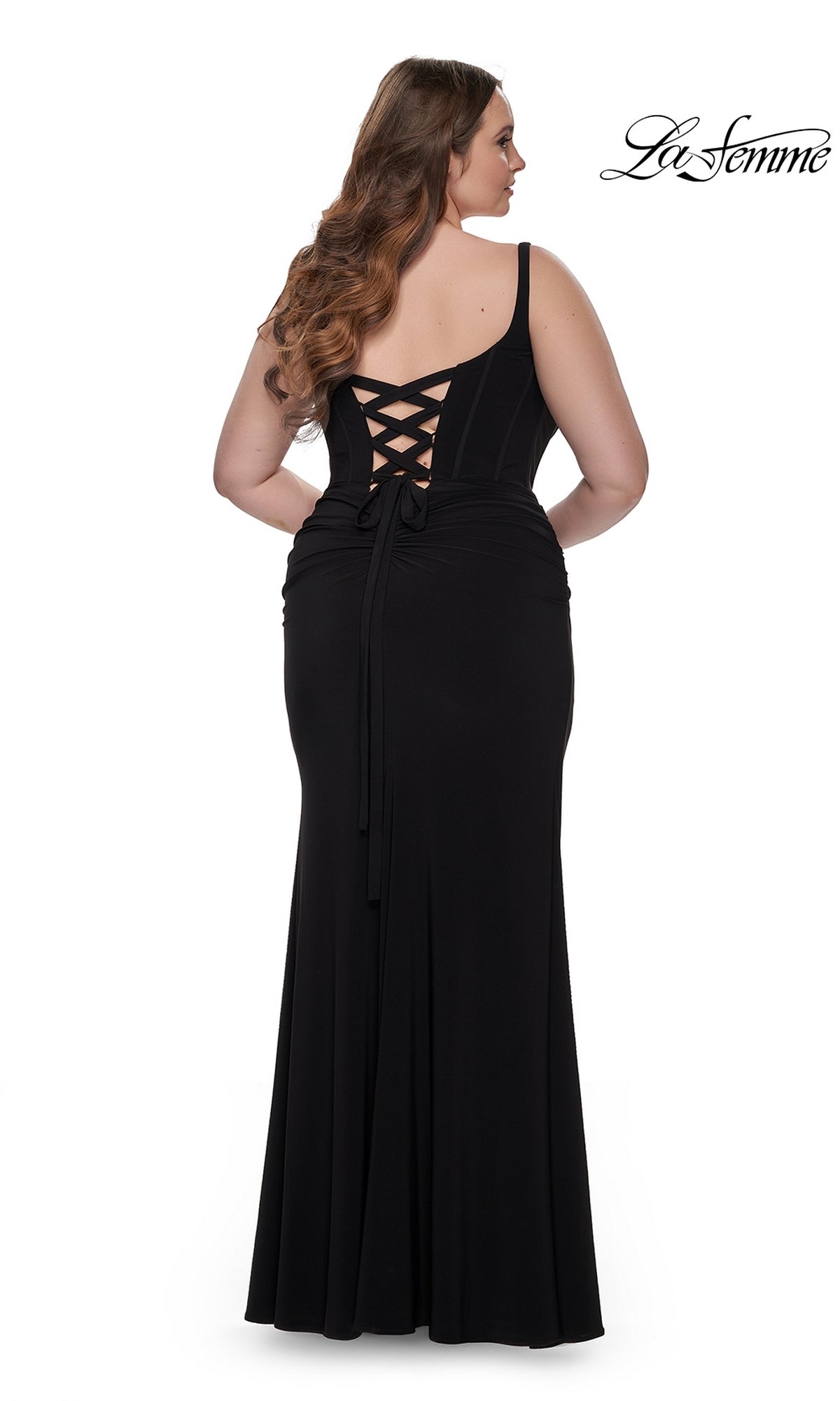 Plus-size woman wearing the La Femme Plus-Size Long Lace-Up Prom Dress 32190 in black, standing and facing away; “La Femme” logo appears in the top right corner.