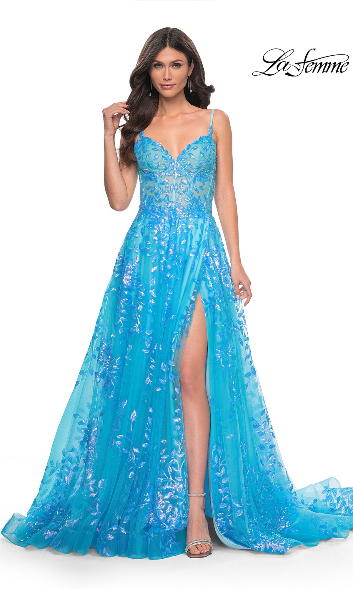 Woman wearing the La Femme Sequin-Print Long A-Line Prom Dress 32223—a bright blue sleeveless gown with a high slit and floral sequin details, posing against a white background.