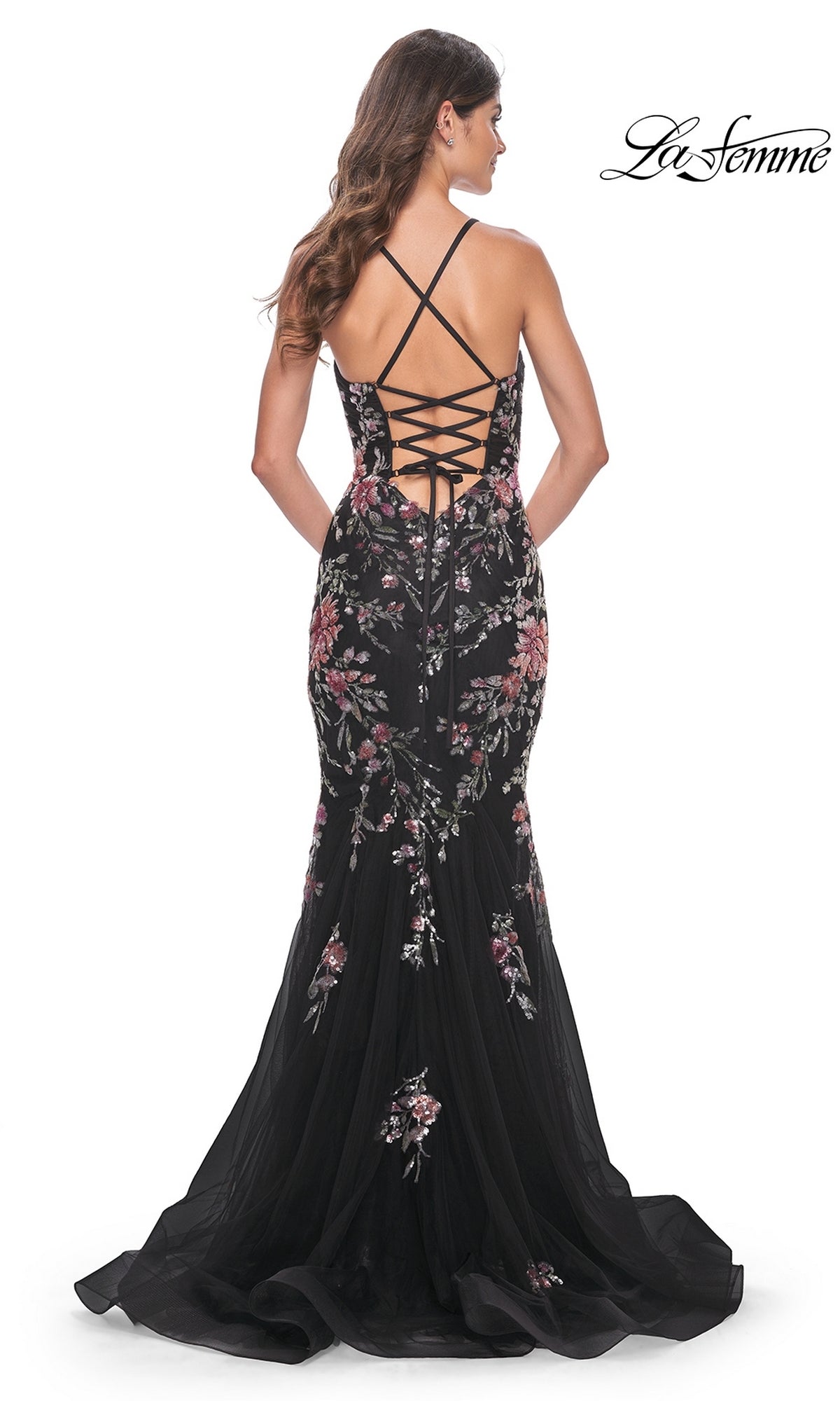 Wearing the La Femme Floral-Lace Long Black Prom Dress 32246, this woman stuns in a mermaid silhouette with pink floral-lace embroidery, an open back with crisscross lace-up straps, and a slight train.