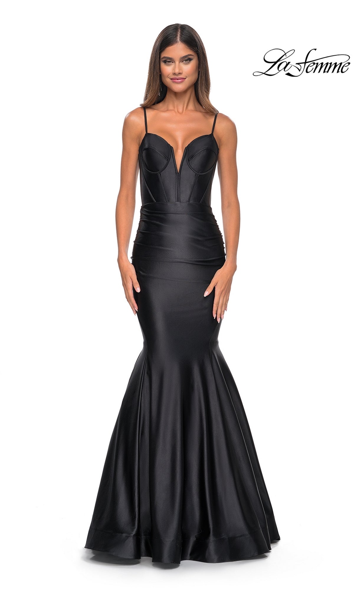 A woman wears the La Femme Long Corset Mermaid Prom Dress 32269, a fitted, sleeveless black gown with thin straps, standing against a white background. The