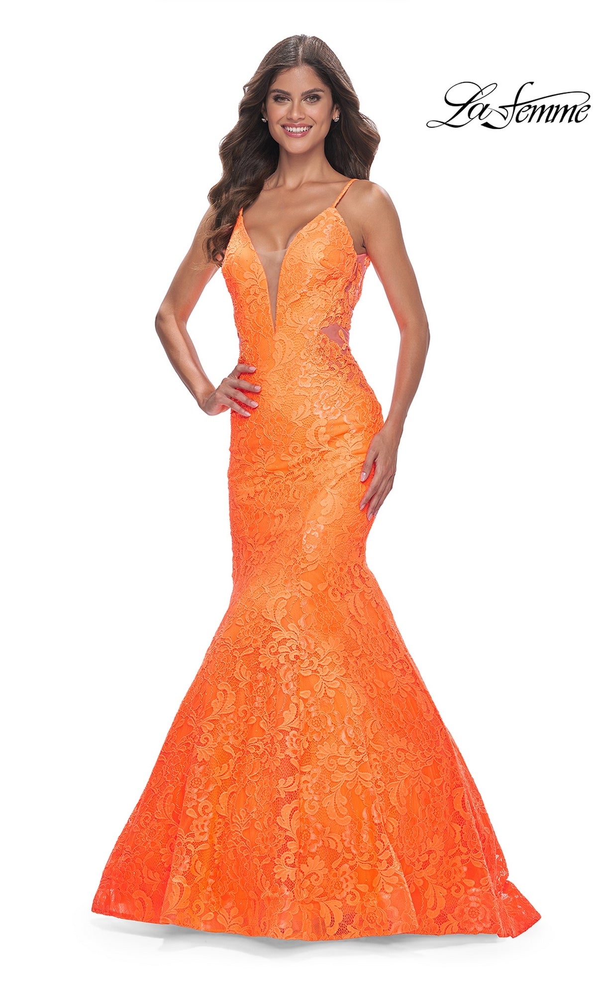A woman smiles in the La Femme Bright Long Lace Mermaid Prom Dress 32314, featuring thin straps, a deep V-neck, and a lace mermaid silhouette. She stands against a white background with the