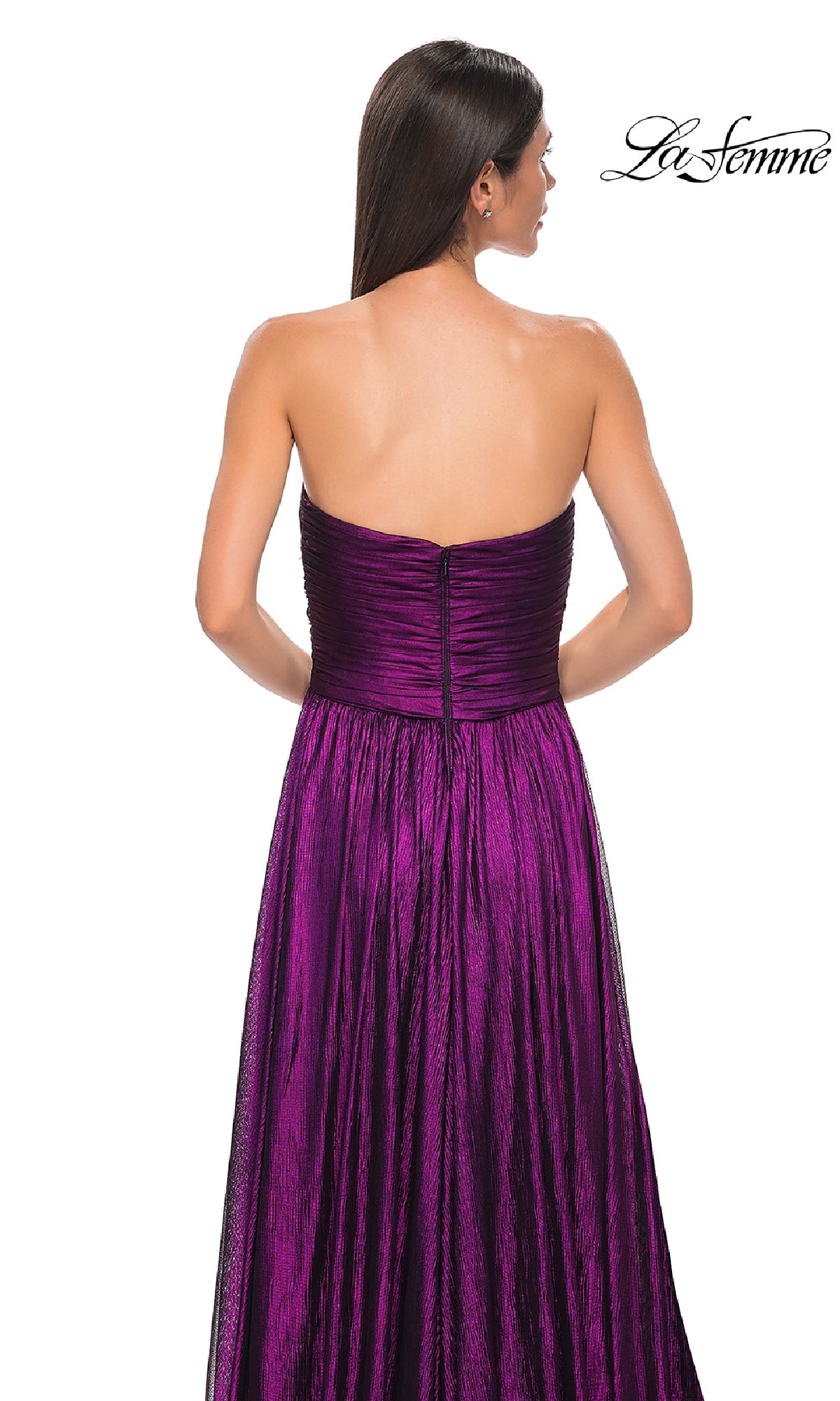 A woman with long dark hair is seen from behind wearing the La Femme 32382, a strapless long metallic prom dress with a fitted bodice and flowing skirt. The