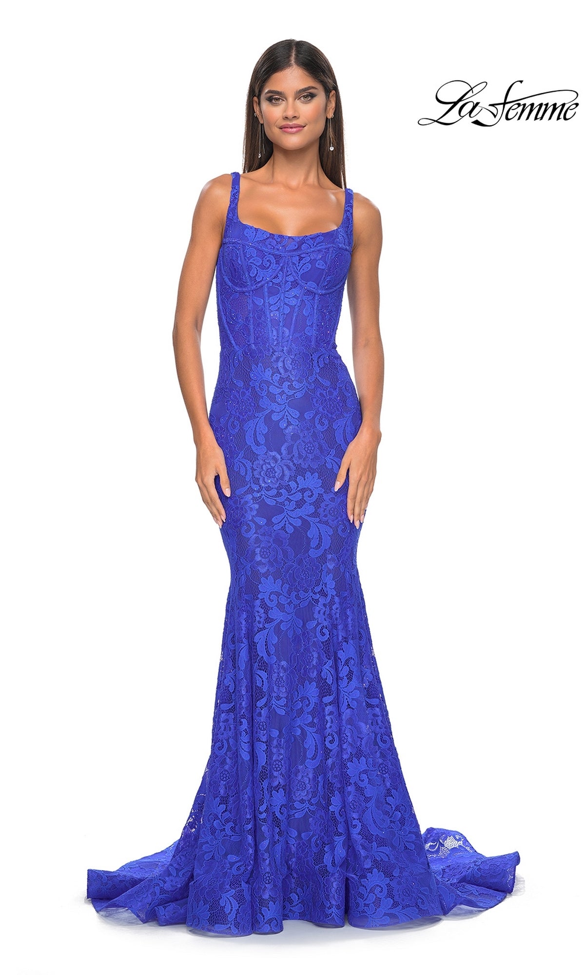 A woman models the fitted, floor-length Long Lace Mermaid Prom Dress: La Femme 32420 in royal blue, featuring wide shoulder straps and a subtle mermaid silhouette, against a plain white background.