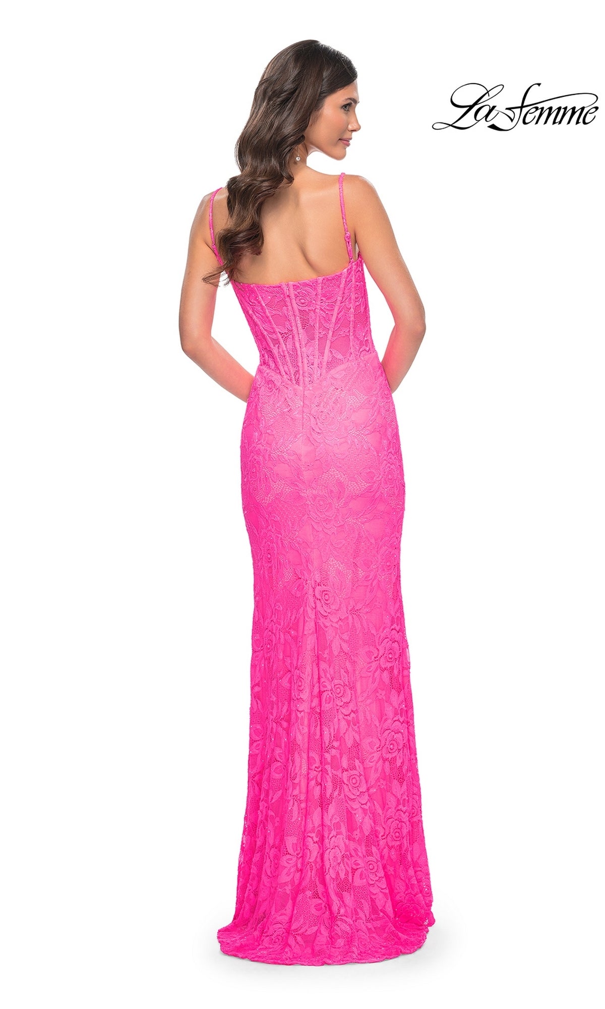 Woman in a fitted, floor-length neon pink lace prom dress with thin straps, shown from the back. This stunning gown is the Neon Pink Long Lace Prom Dress: La Femme 32423.