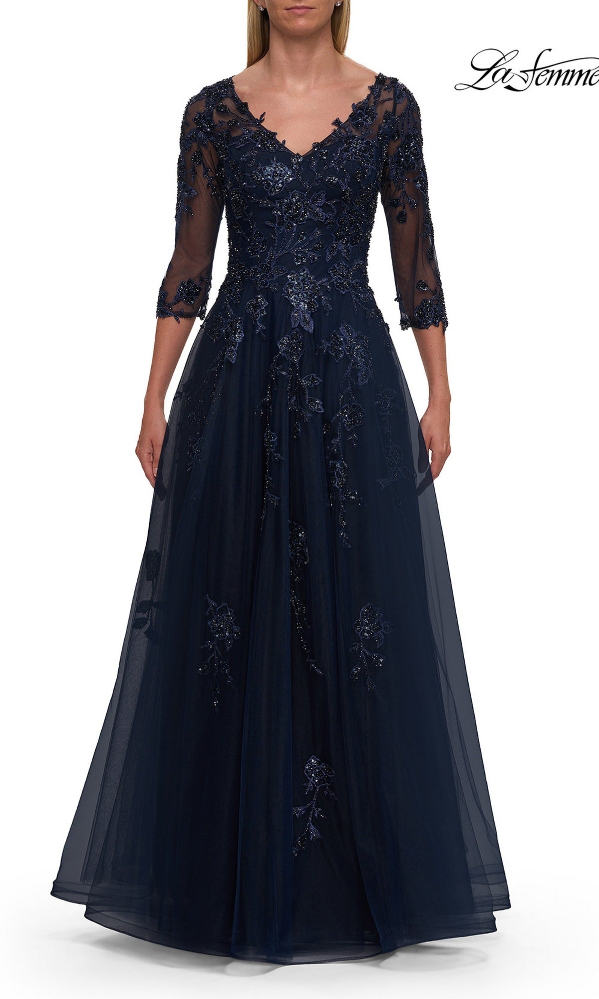 A woman wearing the La Femme 32538 A-Line Tulle Sleeved Formal Dress in navy, featuring a floor-length silhouette, sheer embroidered sleeves, floral lace details, and a V-neckline.