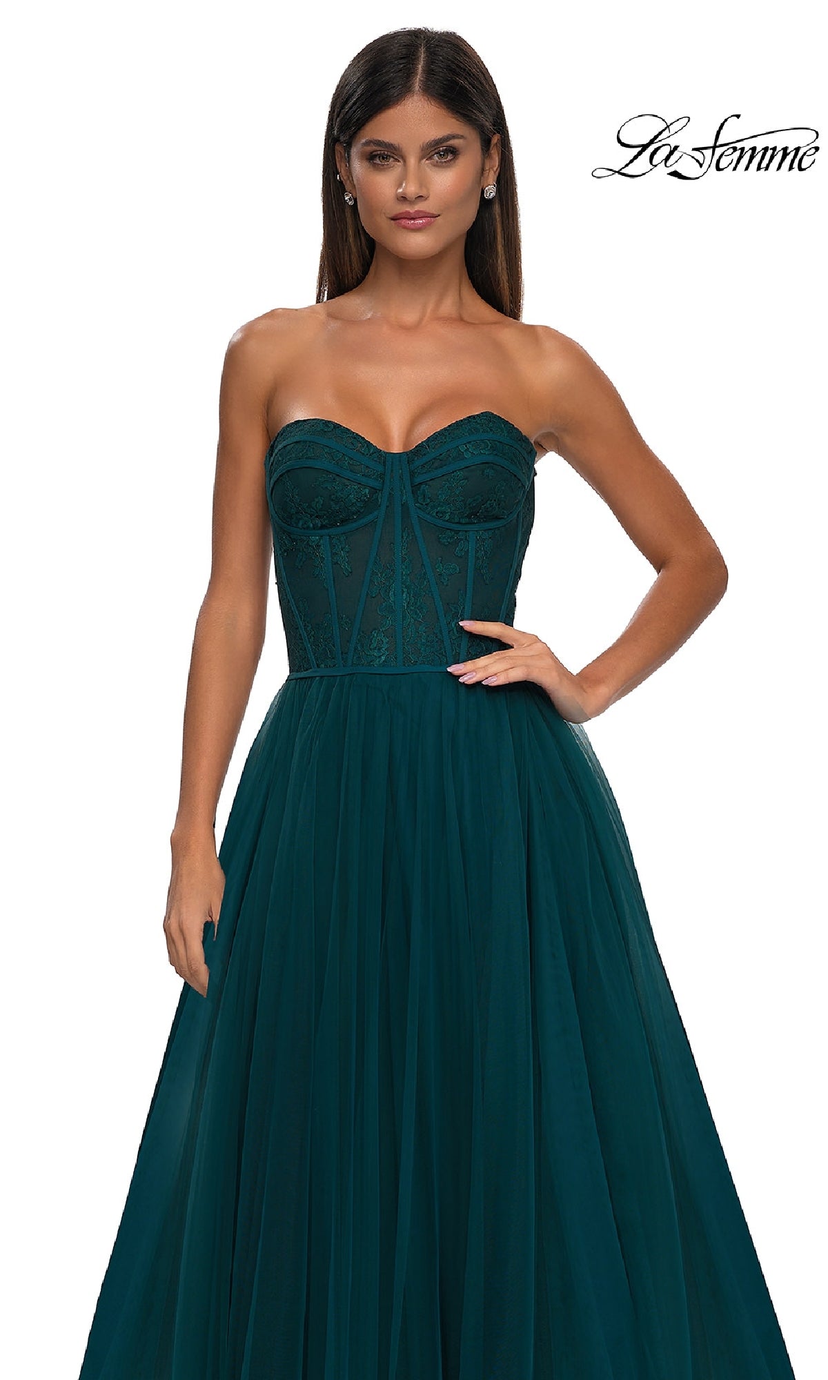 A woman wears the Strapless Long Prom Ball Gown: La Femme 32579, featuring a sweetheart neckline, fitted floral corset bodice, and flowing tulle skirt, standing against a white background with the