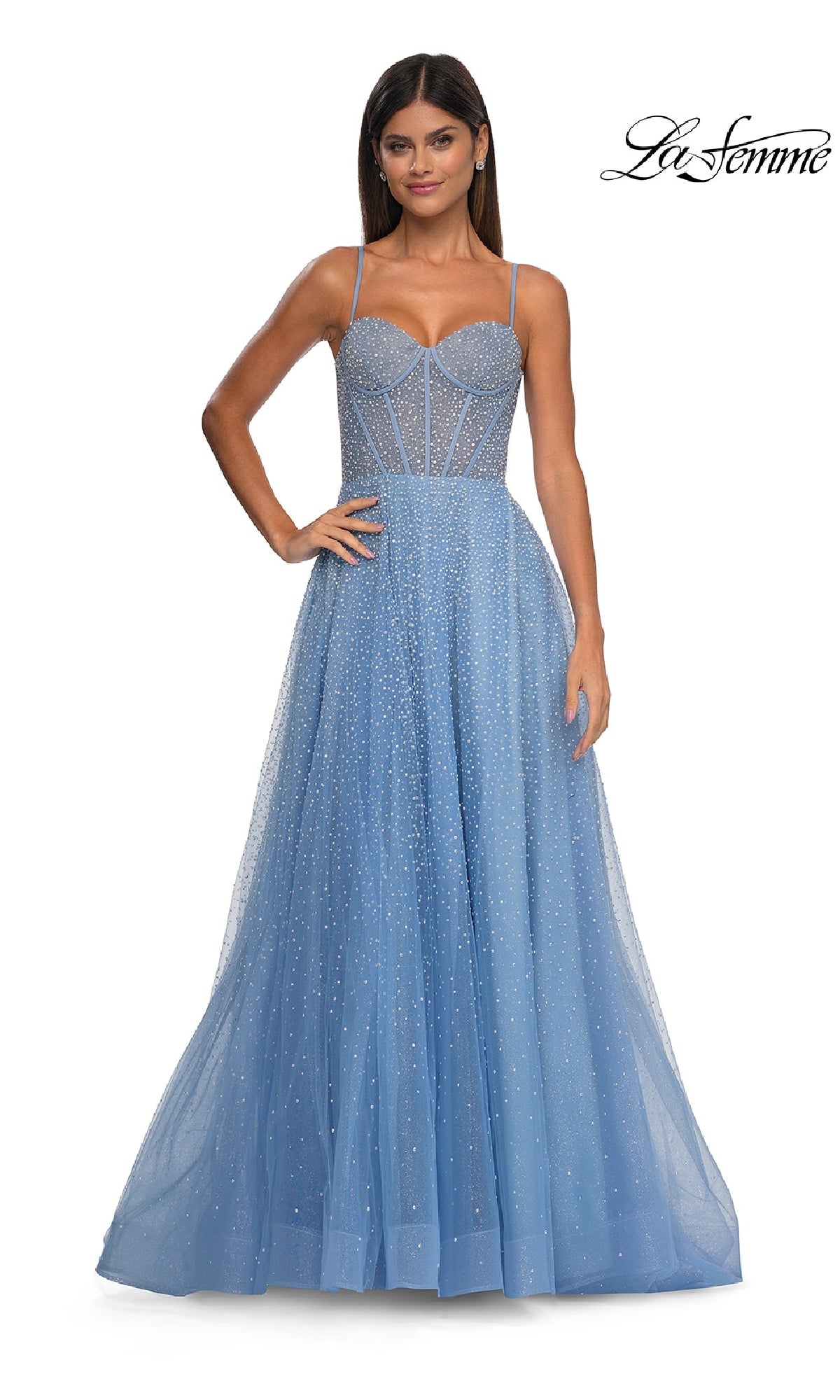 A woman models the Pearl Classic Long Prom Dress: La Femme 32644, a light blue floor-length A-line gown with a sheer embellished bodice and full tulle skirt, standing before a white background. The La Femme logo appears in the top right corner.