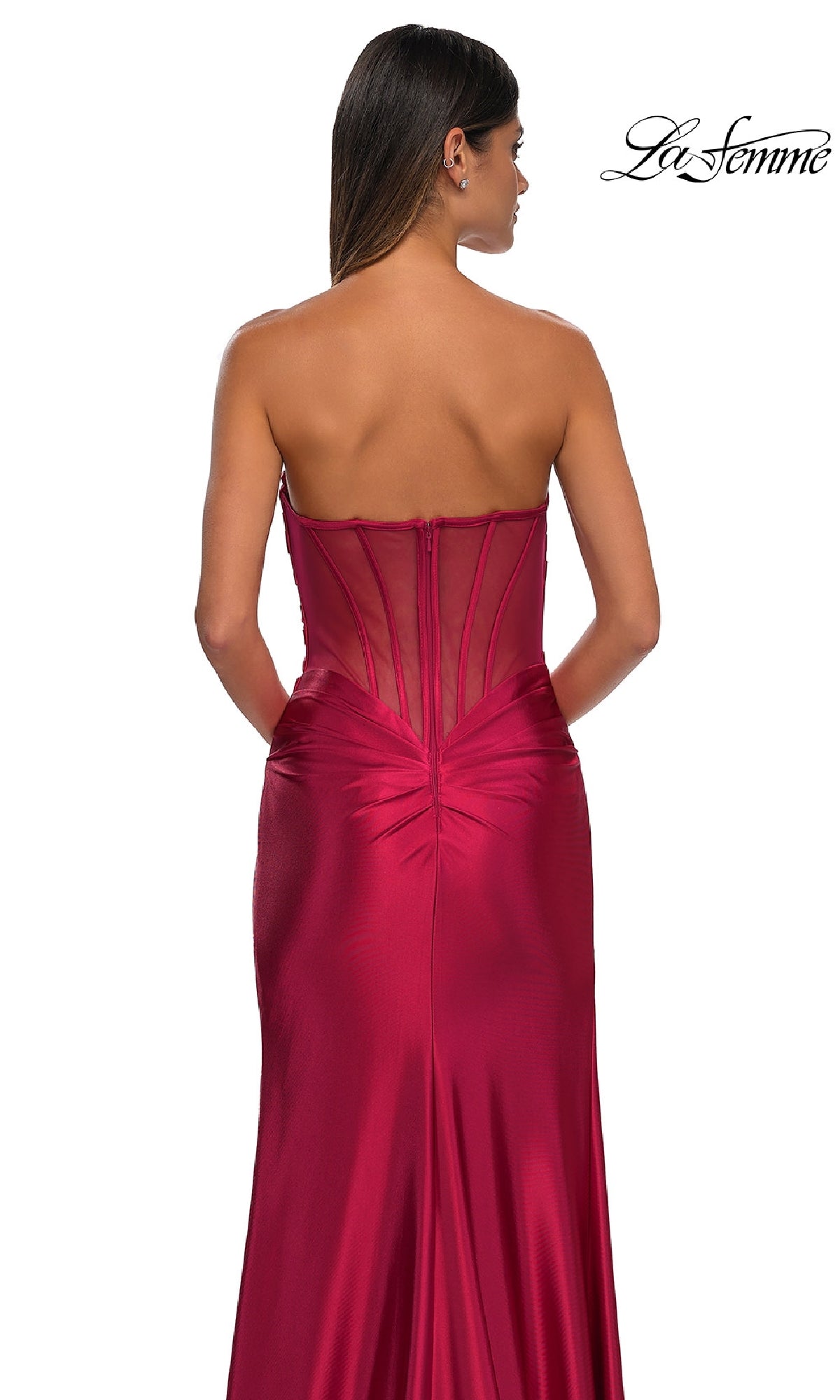 A woman is seen from the back in the Sheer-Back Strapless Prom Gown: La Femme 32649, a red satin dress with a sweetheart neckline, sheer back panel, and ruched detailing. The La Femme logo appears in the top right corner.