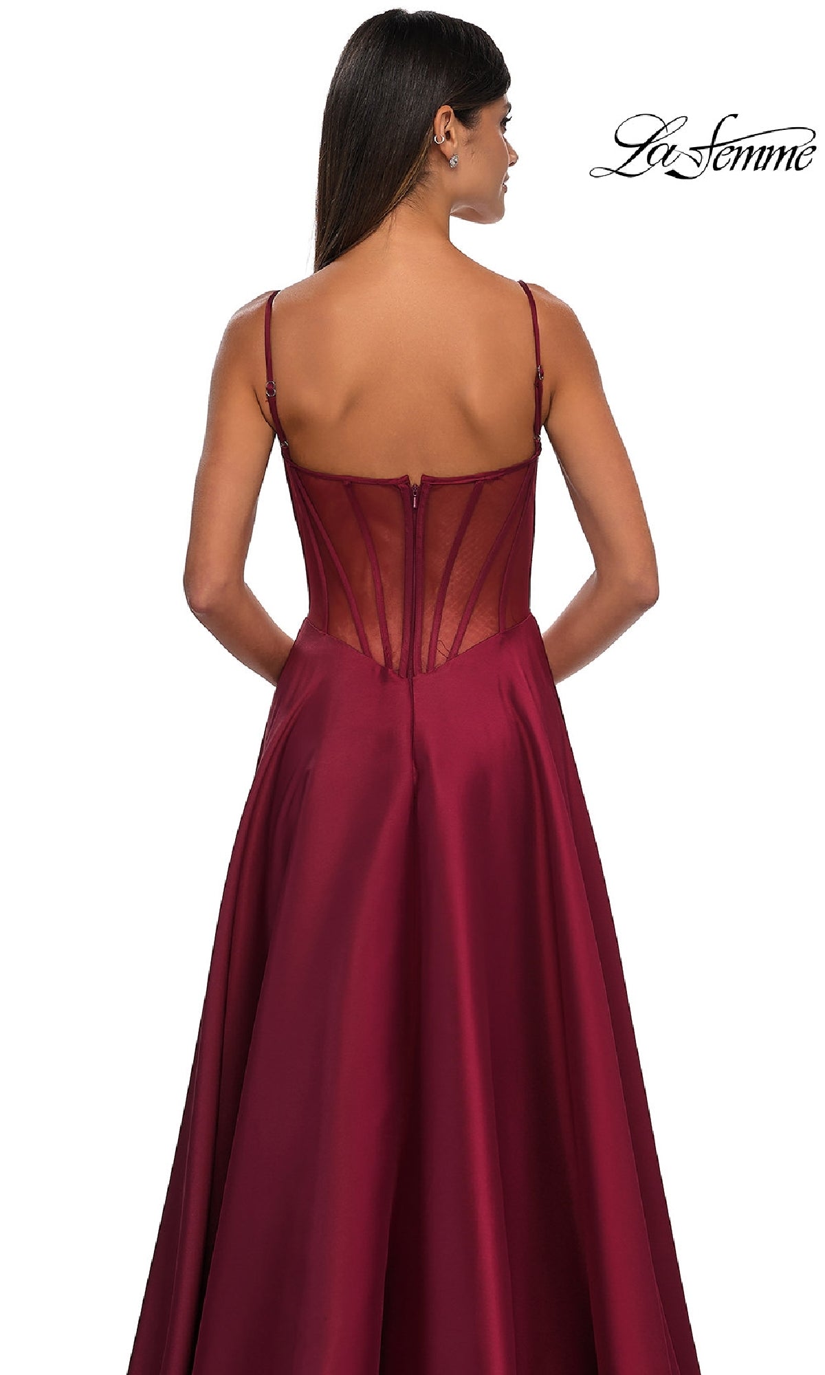 A woman faces away, wearing the Sheer-Corset Long A-Line Prom Gown: La Femme 32670, featuring a sheer-back and flowing stretch Mikado satin skirt. The