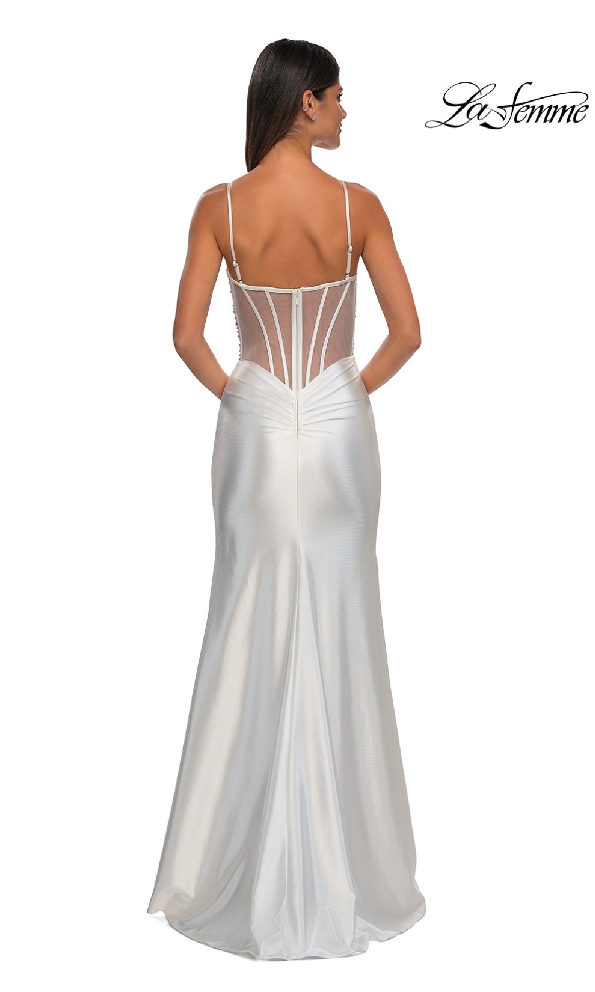 A woman models the La Femme 32691 Long Satin Corset Prom Dress—a floor-length white gown with thin straps, sheer beaded corset back, and pockets.