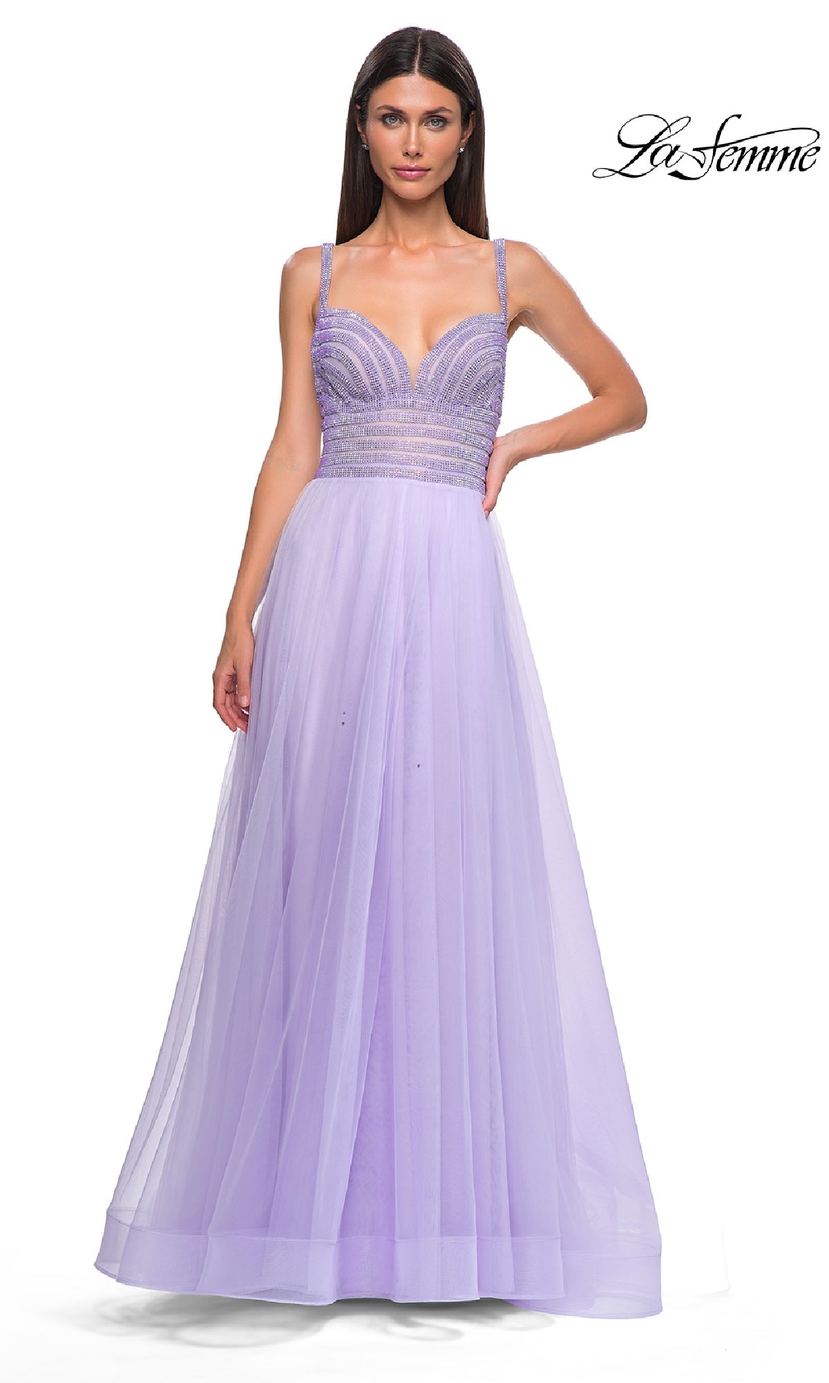 A woman models the La Femme 32714 prom ball gown—a floor-length, a-line lavender dress with a rhinestone-bodice and flowing tulle skirt. The “La Femme” logo is displayed in the top right corner.