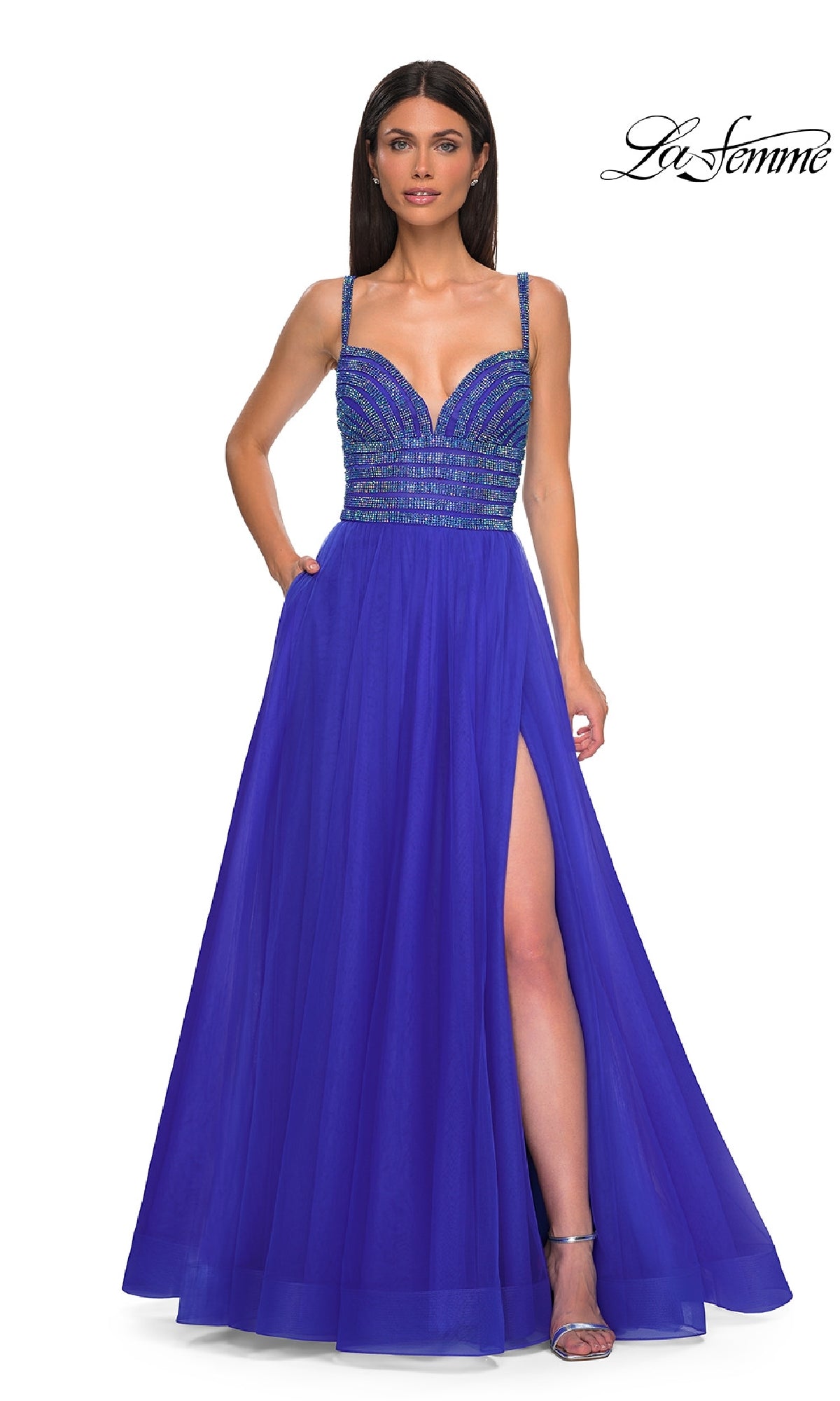 A woman stands facing forward in the La Femme 32714 Rhinestone-Bodice Prom Ball Gown, featuring a royal blue A-line silhouette, thin straps, a rhinestone-beaded bodice, and a thigh-high slit.