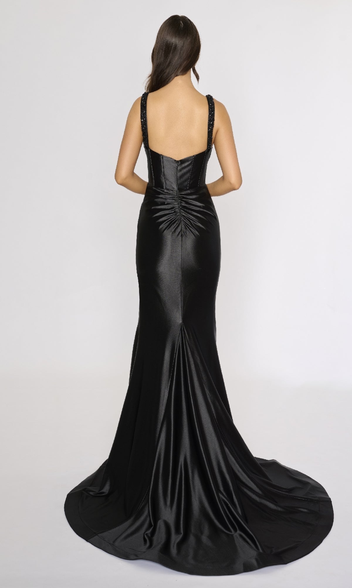 Woman wearing the Nina Canacci 3271 long formal dress, featuring a sleeveless design, fitted corset bodice, flared train, and gathered back detail, standing against a plain white background.