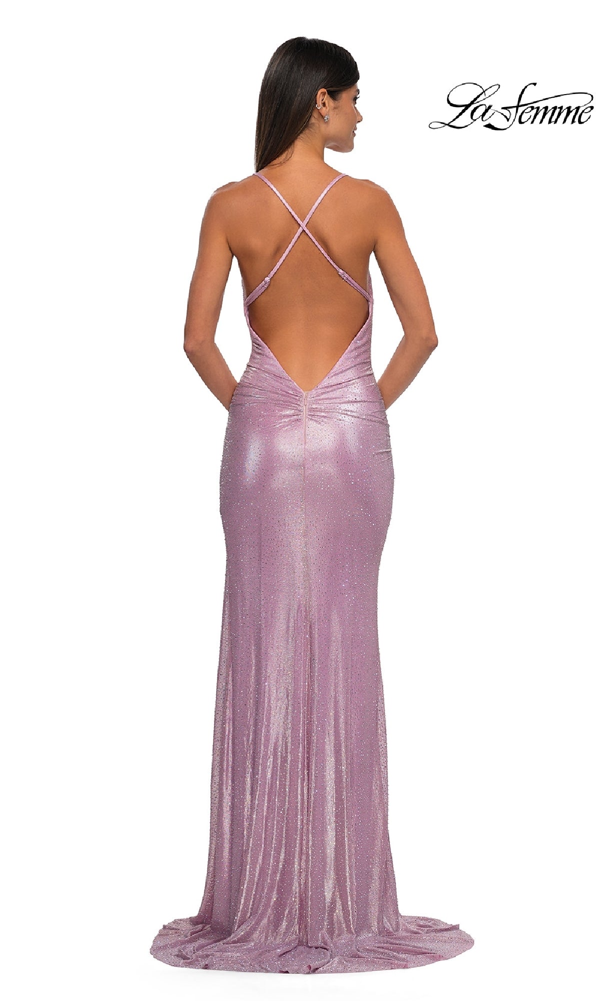 A woman in a floor-length, shimmery light purple Metallic-Jersey Long Prom Dress (La Femme 32835) with a low open back and crisscross straps, shown from behind.