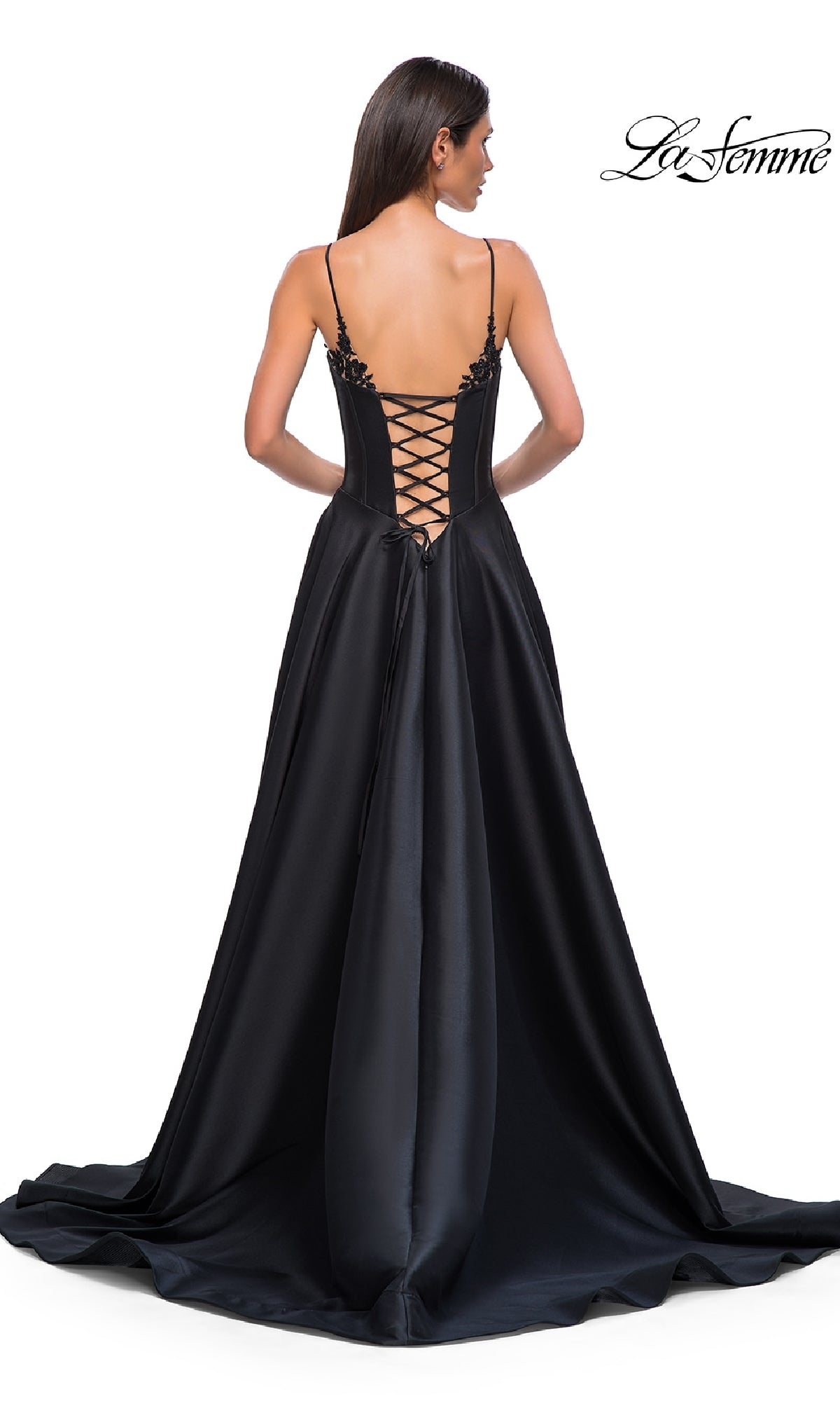 A woman in the Lace-Up Long Mikado Prom Dress (La Femme 32878) stands with her back to the camera, showcasing elegant thin straps and a lace-up detail.