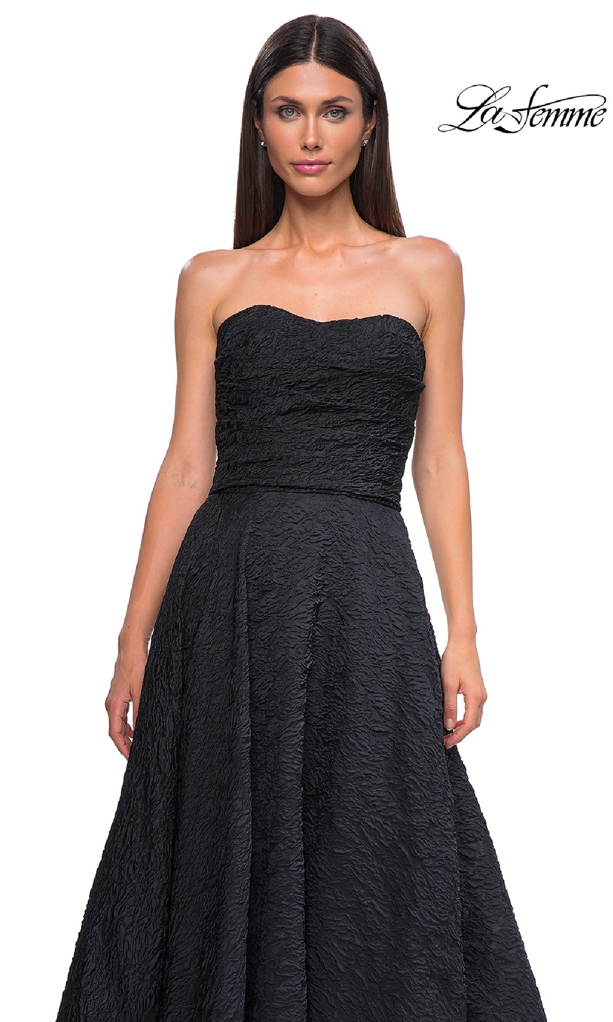 A woman in the La Femme 32893 textured strapless black prom dress with a full skirt stands against a white background. The La Femme logo appears in the top right corner.