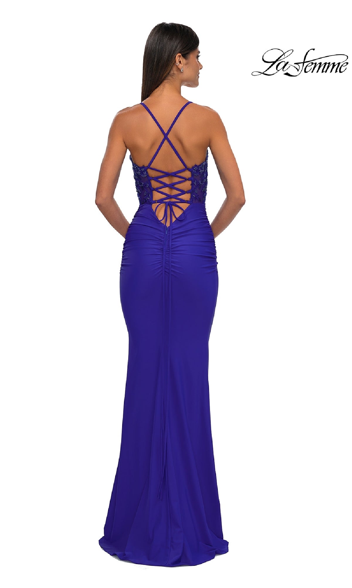 Woman in a floor-length La Femme 32920 beaded-bodice long prom dress stands with her back to the camera, featuring elegant ruching and a crisscross lace-up back.
