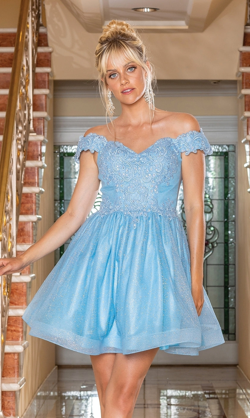 A woman in the Off-the-Shoulder Short Pastel Hoco Dress 3292, featuring light blue lace and tulle, stands indoors near a staircase with ornate railings.