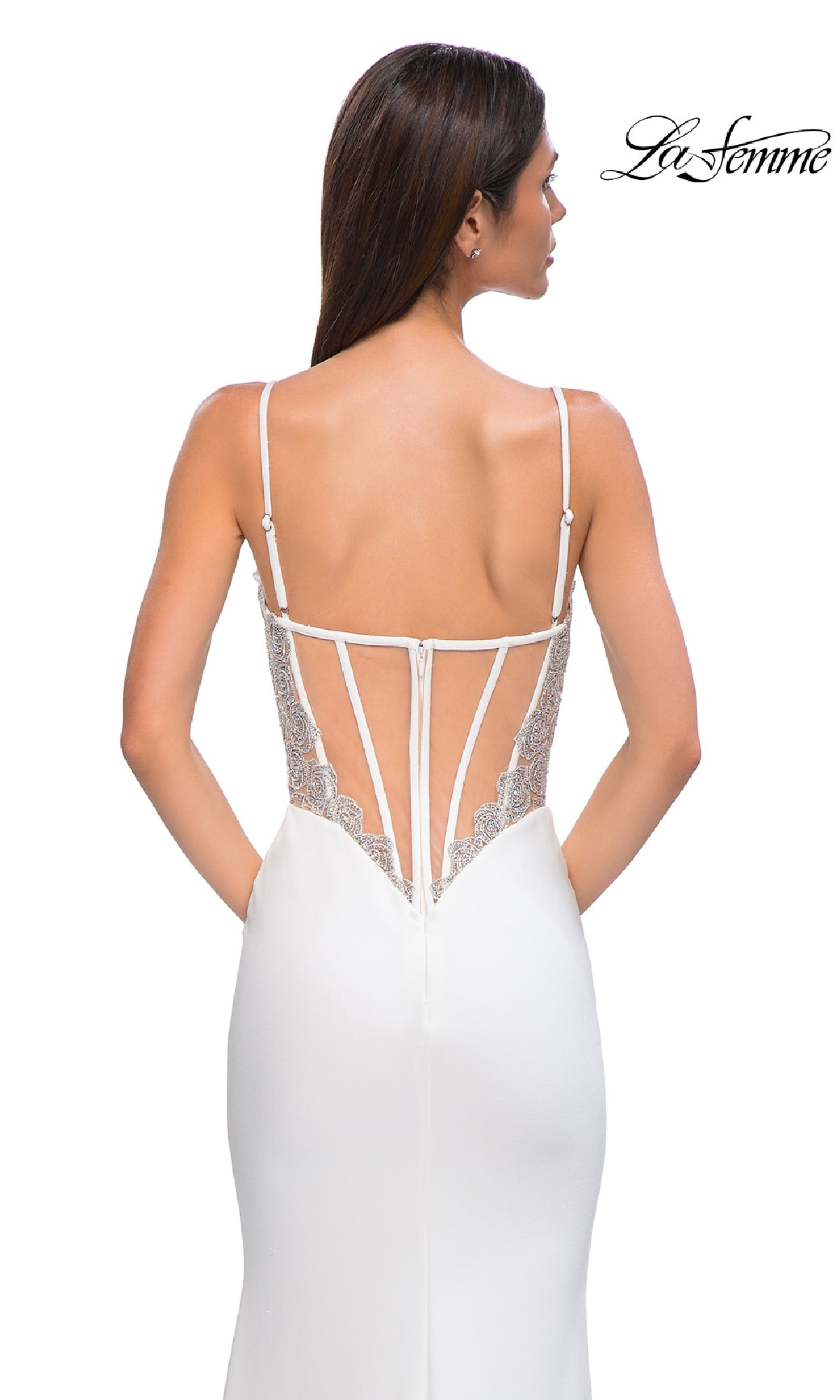 A woman in a white Beaded-Corset Long Prom Dress (La Femme 32930) with thin straps, lace detailing, and a low back faces away from the camera against a plain background. The La Femme logo appears in the top right corner.