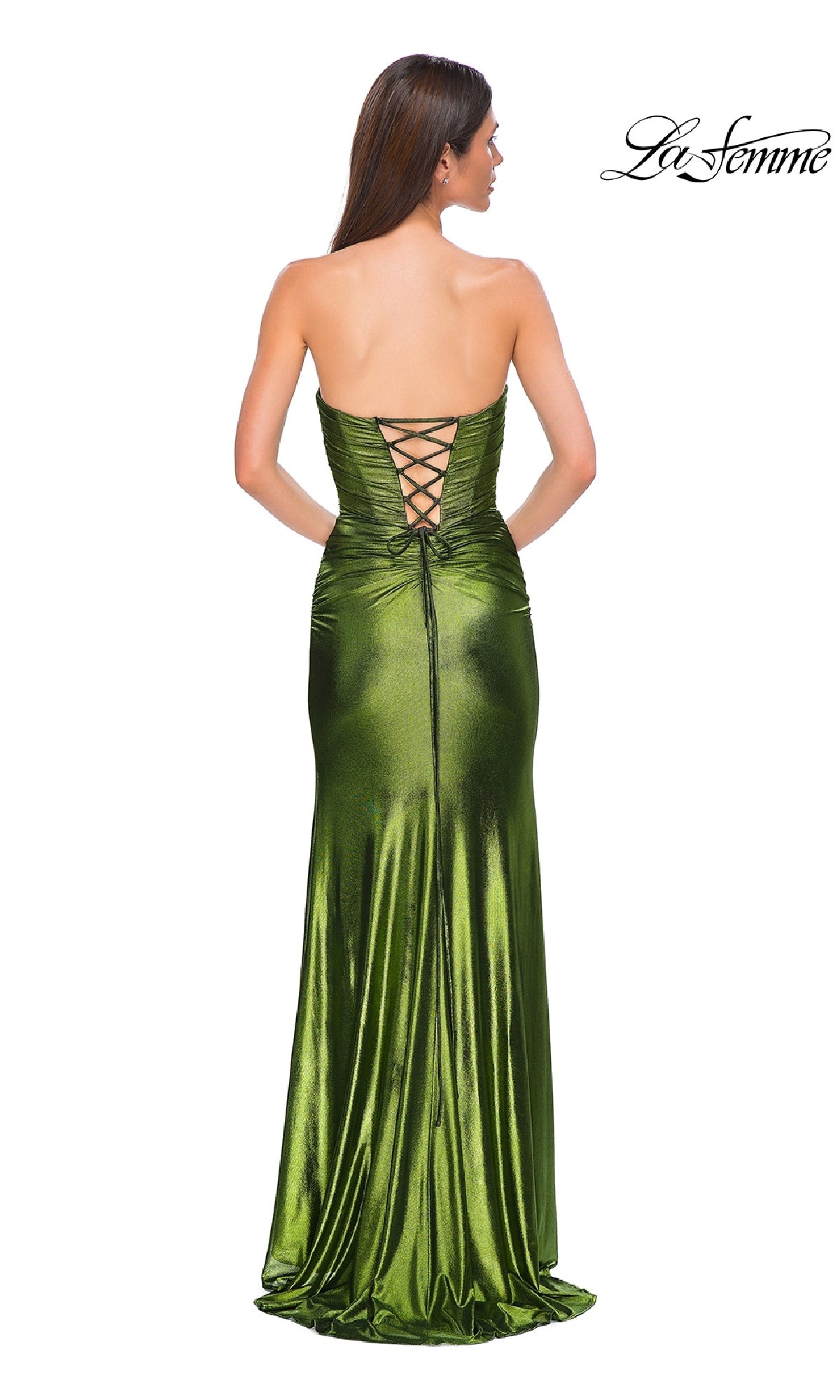 A woman stands facing away, wearing the La Femme 32946 strapless long metallic prom dress in shiny green. The fitted, floor-length gown features a sweetheart neckline and lace-up back for an elegant look.