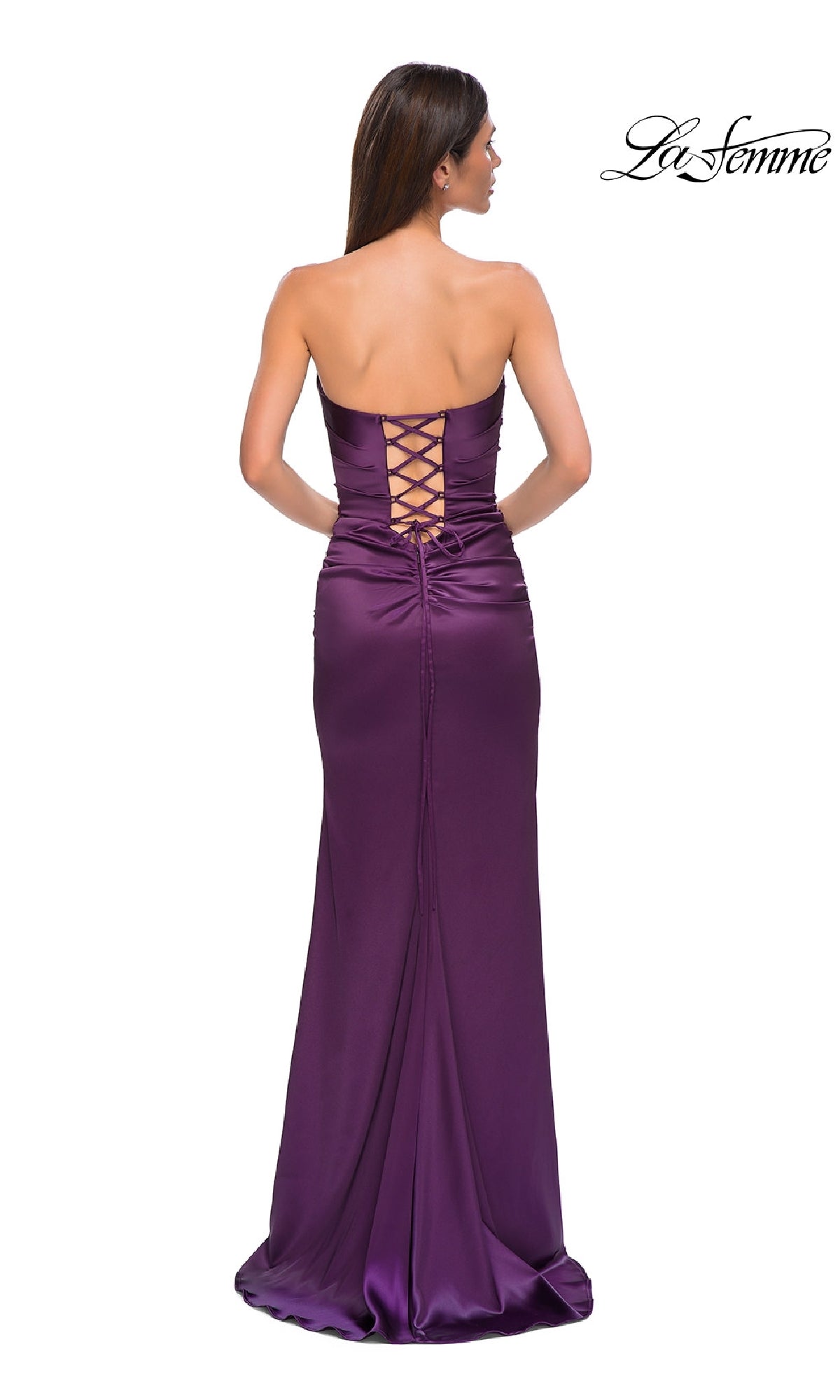 A woman stands elegantly with her back to the camera in the La Femme 32952 strapless long satin prom dress, featuring a floor-length silhouette and lace-up back detail.