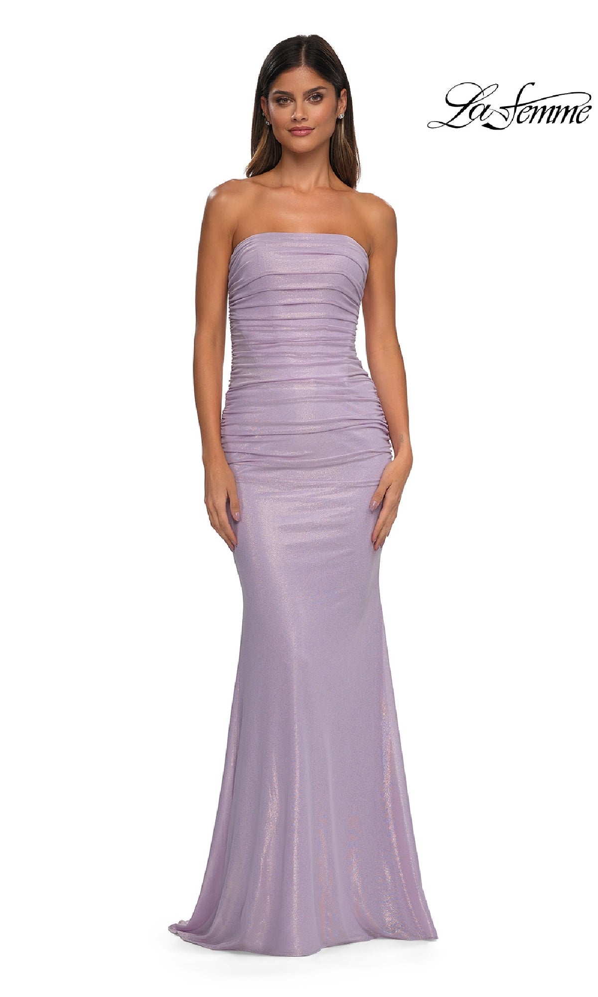 A woman modeling the Strapless Long Tube Prom Dress: La Femme 33033, featuring a metallic finish and ruched corset-style bodice, stands against a plain white background.