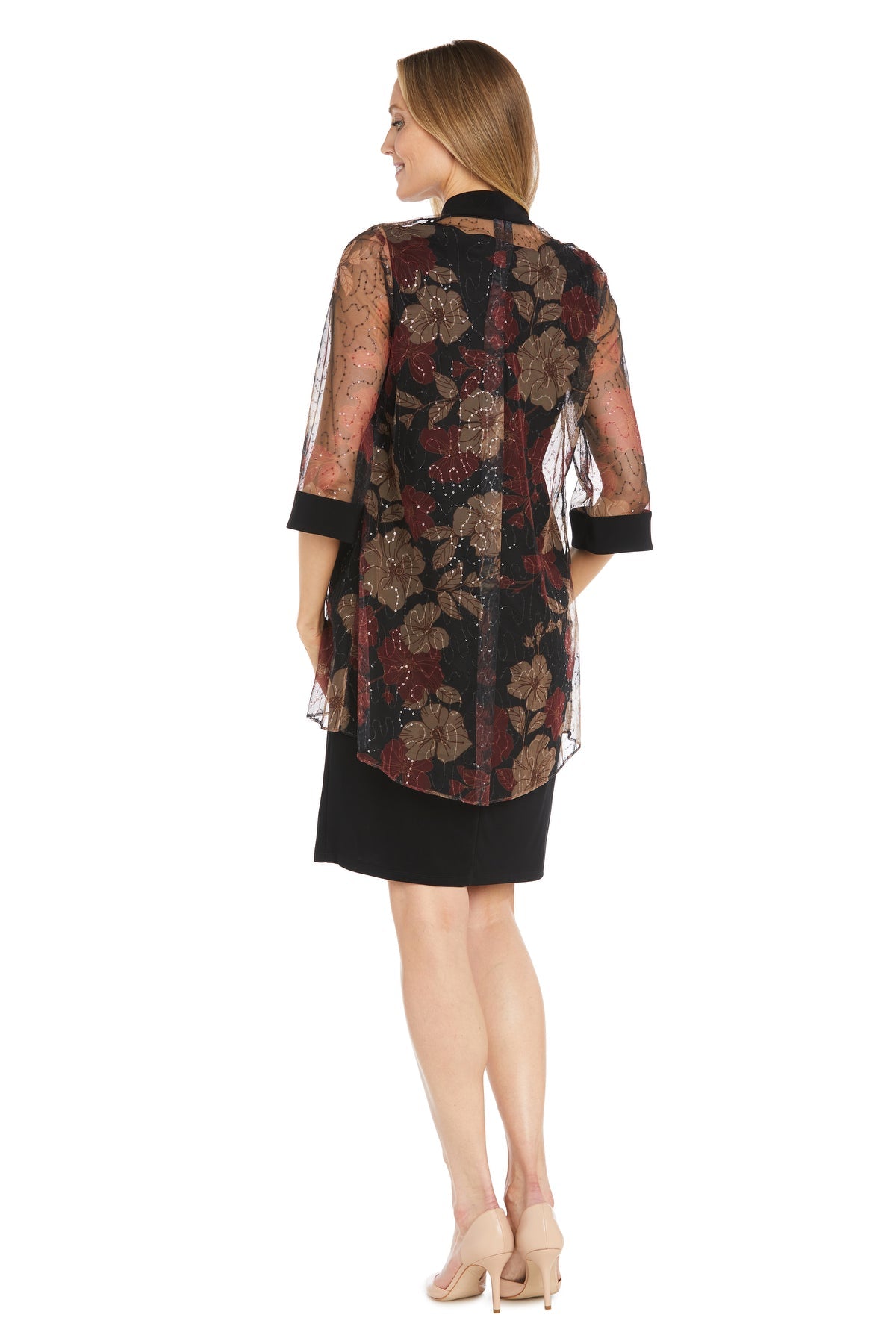 Woman facing away, wearing the Petite Two-Piece Party Dress: R&M Richards 3312—knee-length with a sheer floral overlay—paired with nude heels against a white background.
