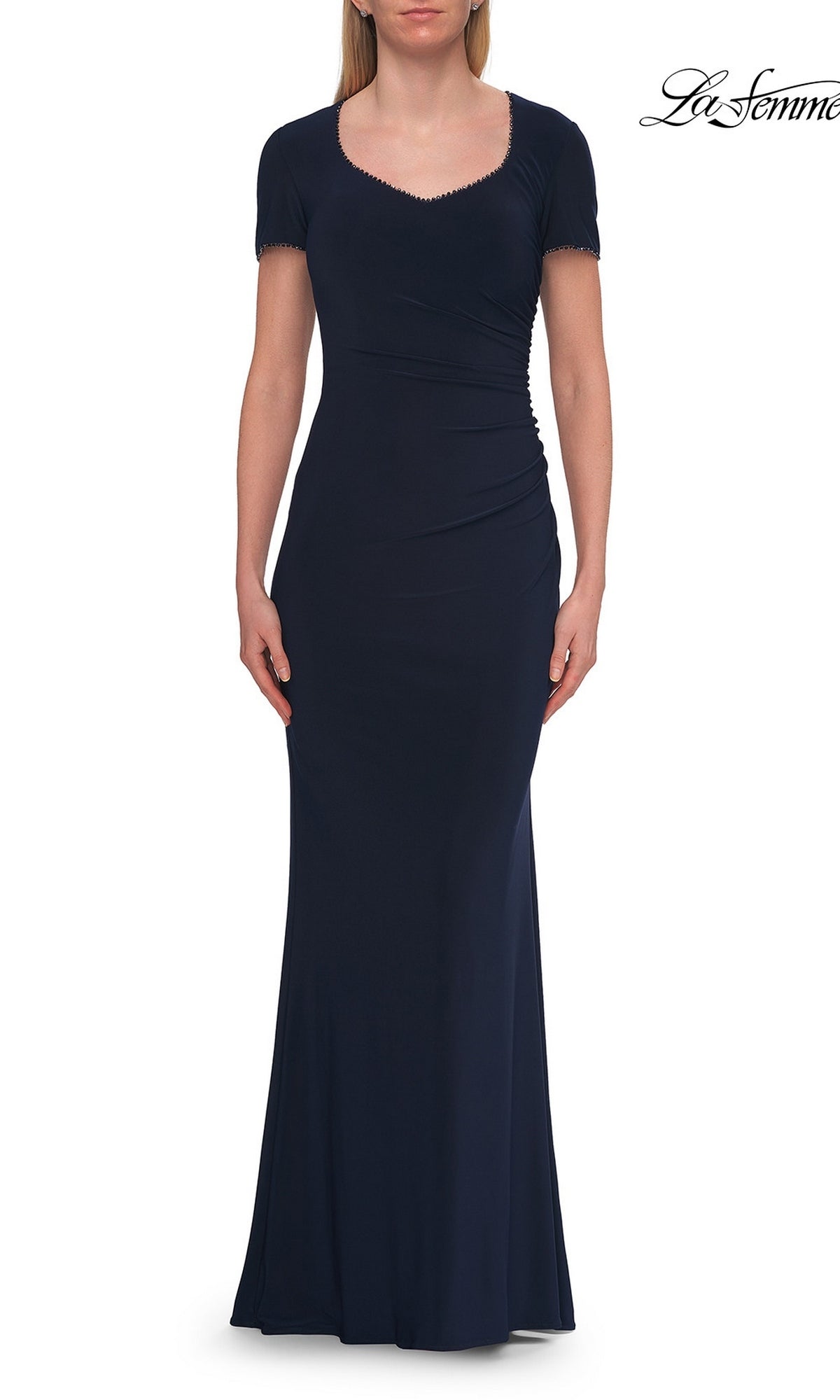A woman wearing the La Femme 33146 Short Sleeve Long Jersey Formal Dress in navy stands with her arms at her sides against a white background.