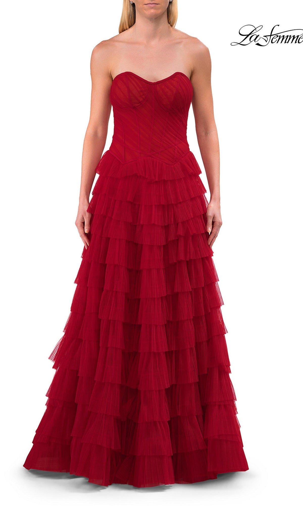 A woman stands against a white background wearing the La Femme 33202 Strapless Ruffle Prom Ball Gown—a floor-length red dress featuring a sweetheart neckline, fitted bodice, and a skirt adorned with multiple layered ruffles.